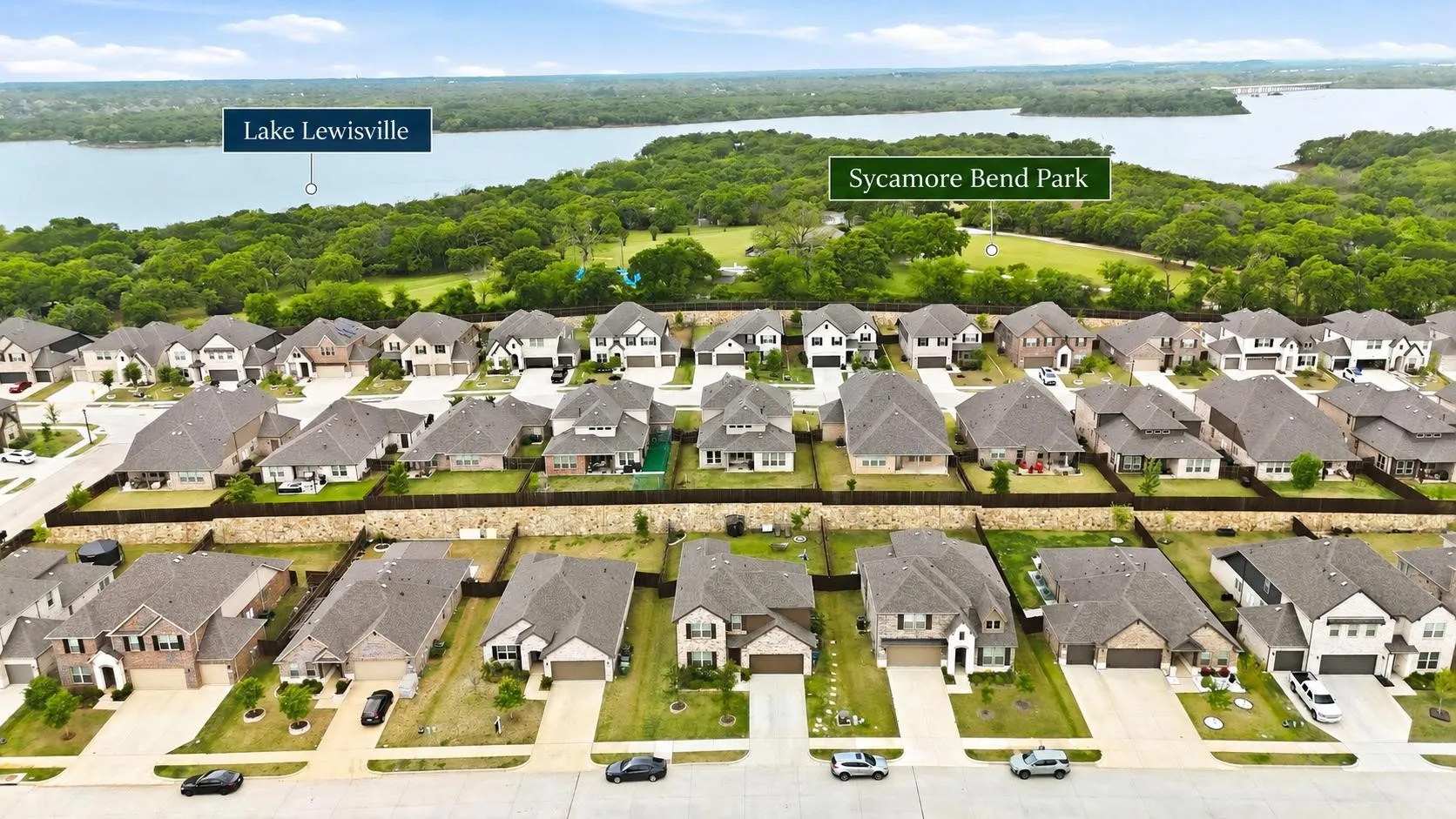 Newly constructed residential community featuring modern architecture with consistent rooflines, manicured front lawns, and mature tree-lined streetscaping