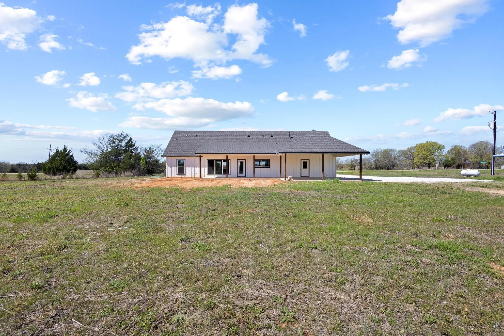 The property features a white exterior, a dark grey roof, and a covered porch