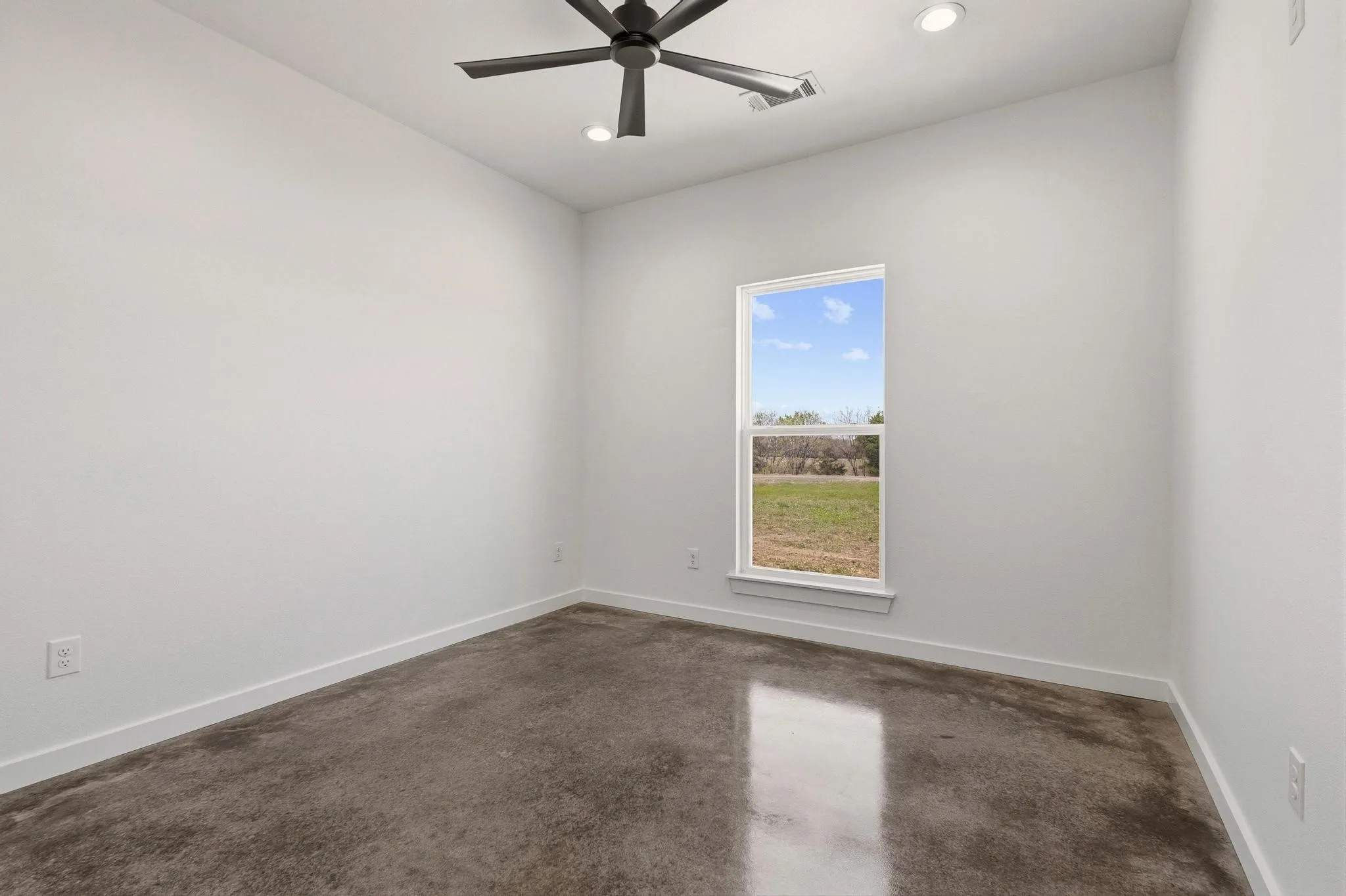 This room features a window providing views of the surrounding land, a ceiling fan, and recessed​​‌​​​​‌​​‌‌​‌‌​​​‌‌​‌​‌​‌​​​‌​​ lighting