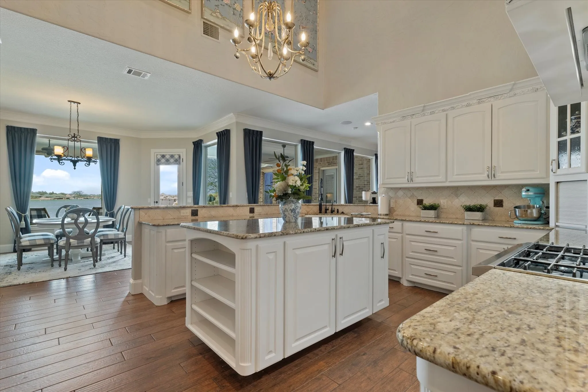 The property features a kitchen with white cabinetry, granite countertops, and hardwood flooring