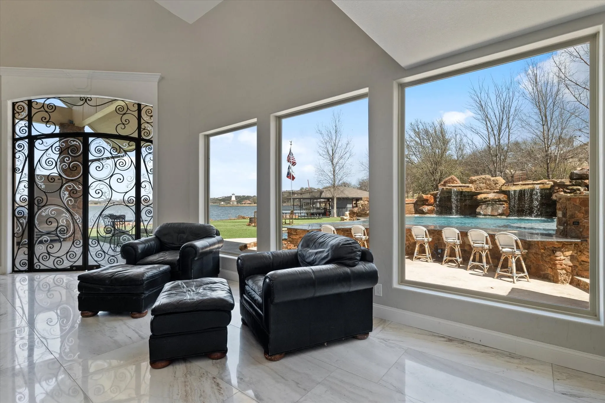 This room features expansive windows offering views of a pool with waterfalls and a body of water
