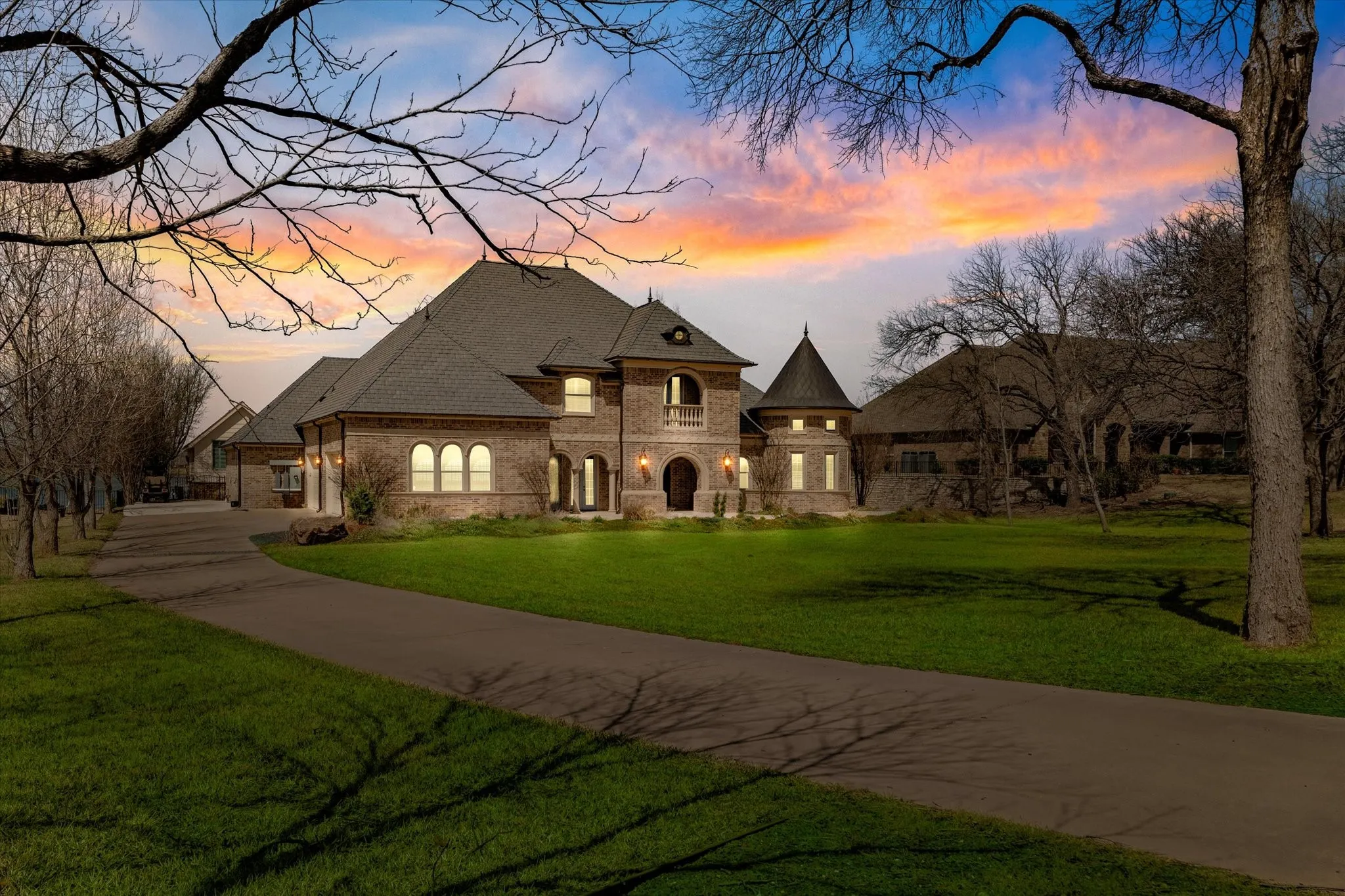 The property features a brick exterior, a paved driveway, and a well-maintained lawn