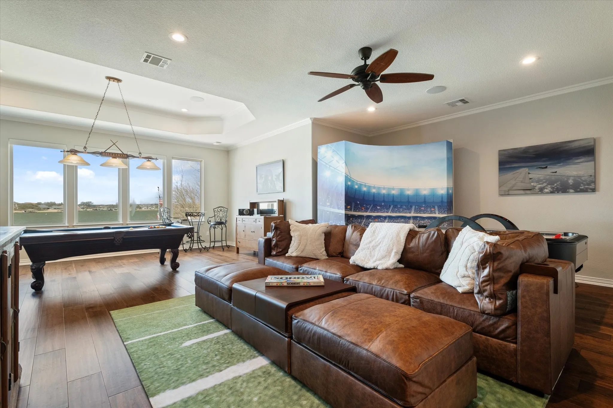 This spacious room features hardwood flooring, a ceiling fan, and recessed lighting