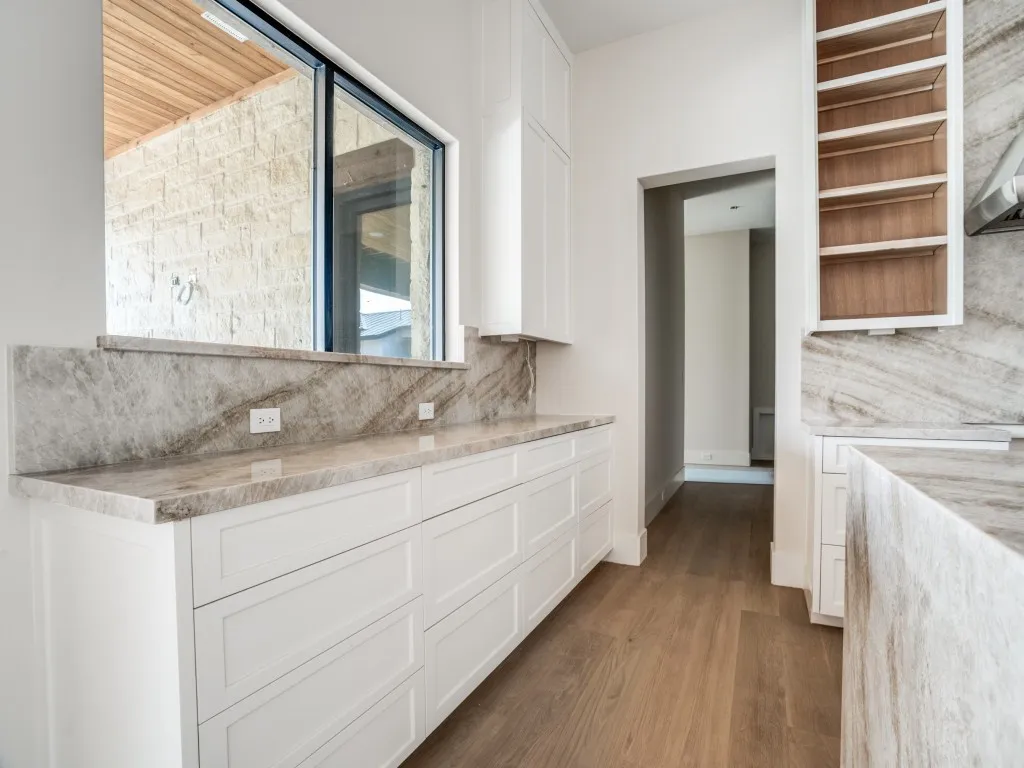 Additional workspace in the kitchen overlooks the large covered back patio and swimming pool.