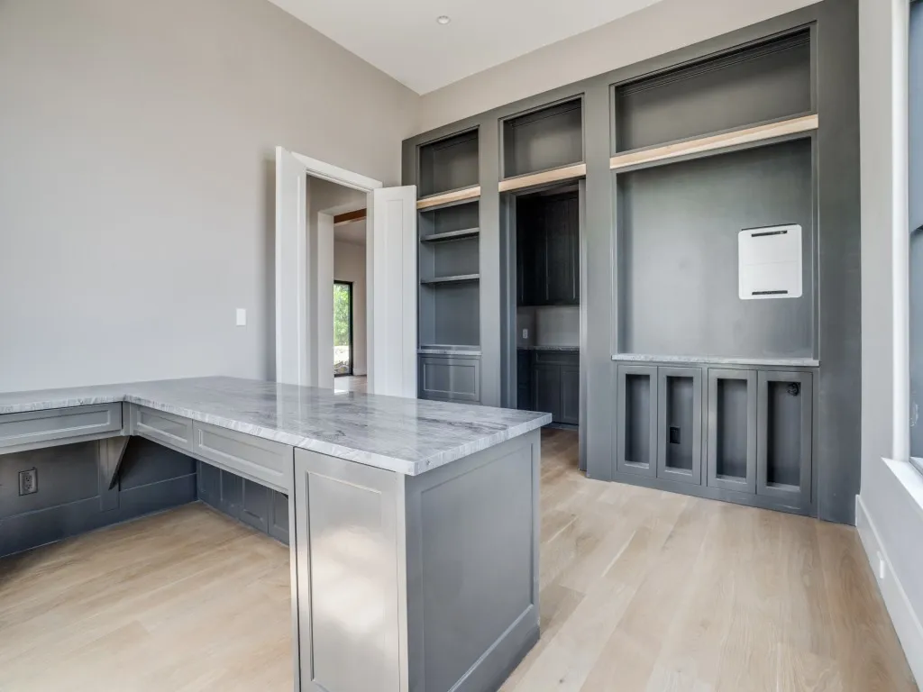 The stately office includes a built in desk and a hidden storage room.