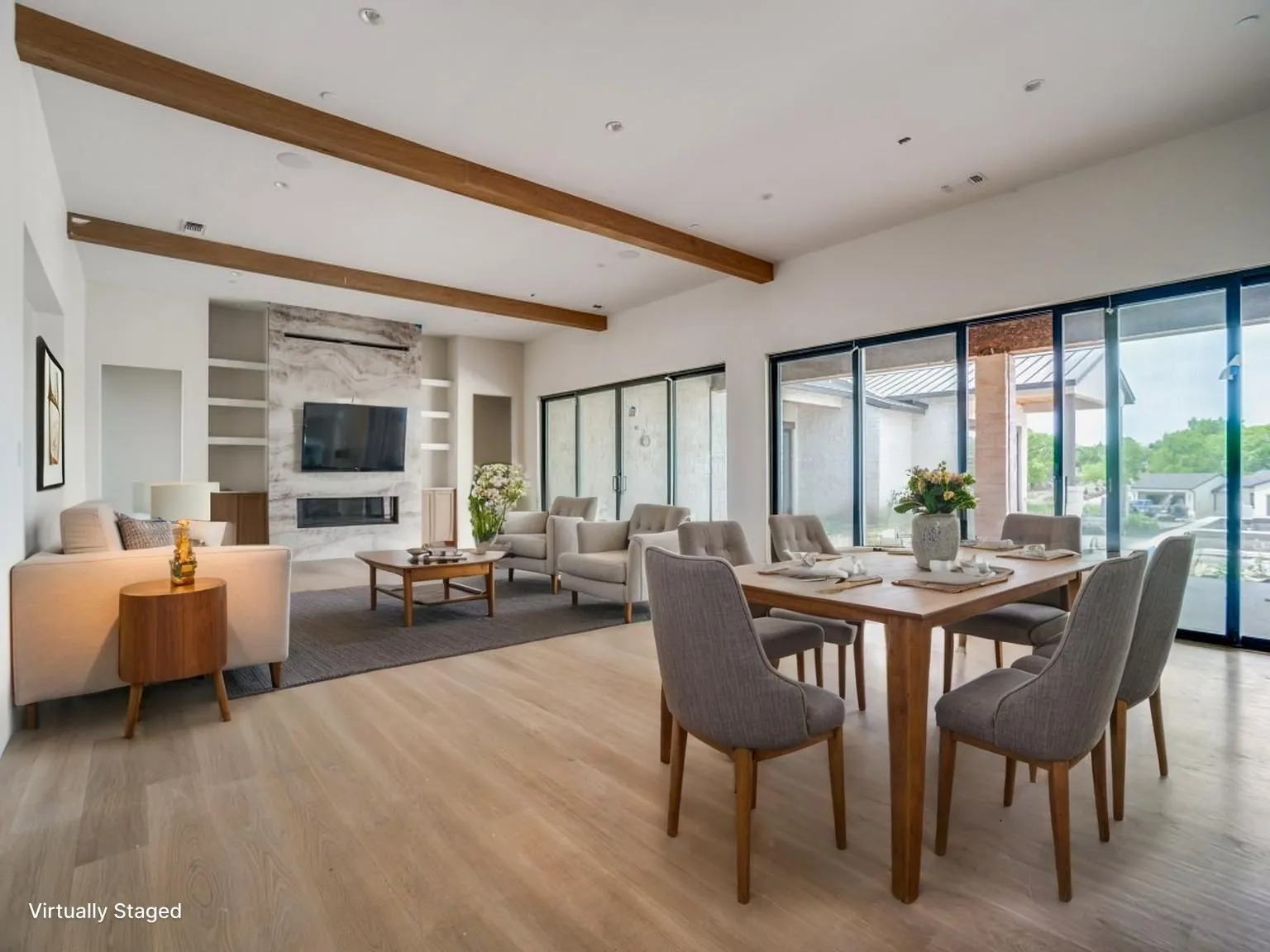 Expansive dining and living area features a wall of windows and sliders overlooking the backyard. This photo is virtually staged.