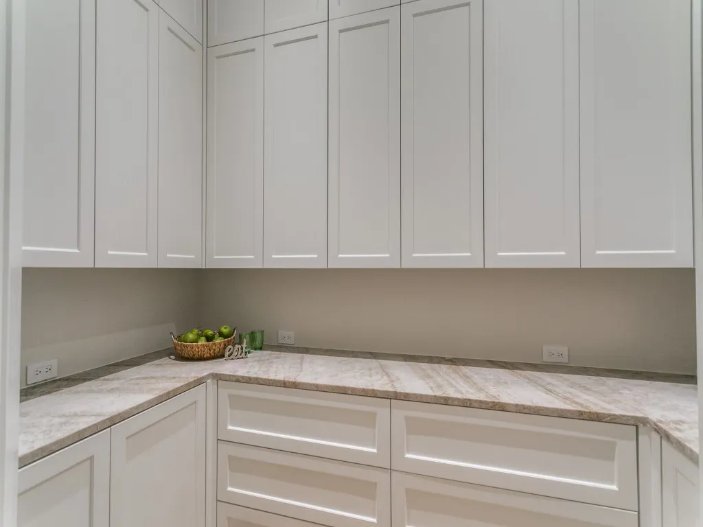 This walk in pantry prep space features space for a built-in microwave and a multitude of storage.