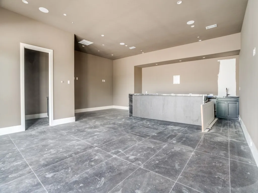 Pool house recreation room overlooks the swimming pool and features a bar, half-bath, and room for a card table, pool table, or lounge area.