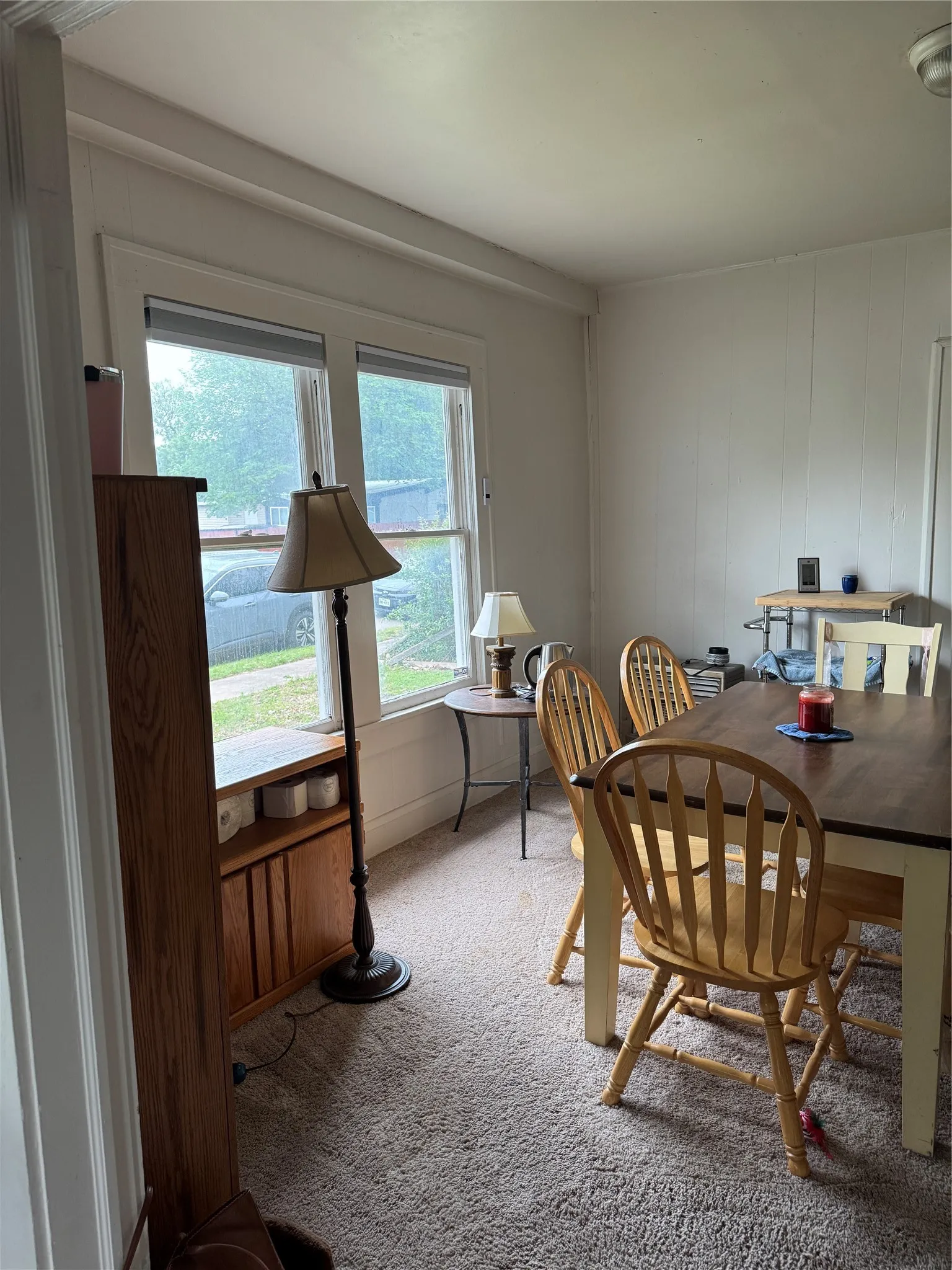 Dining area featuring light colored carpet and a decorative wall