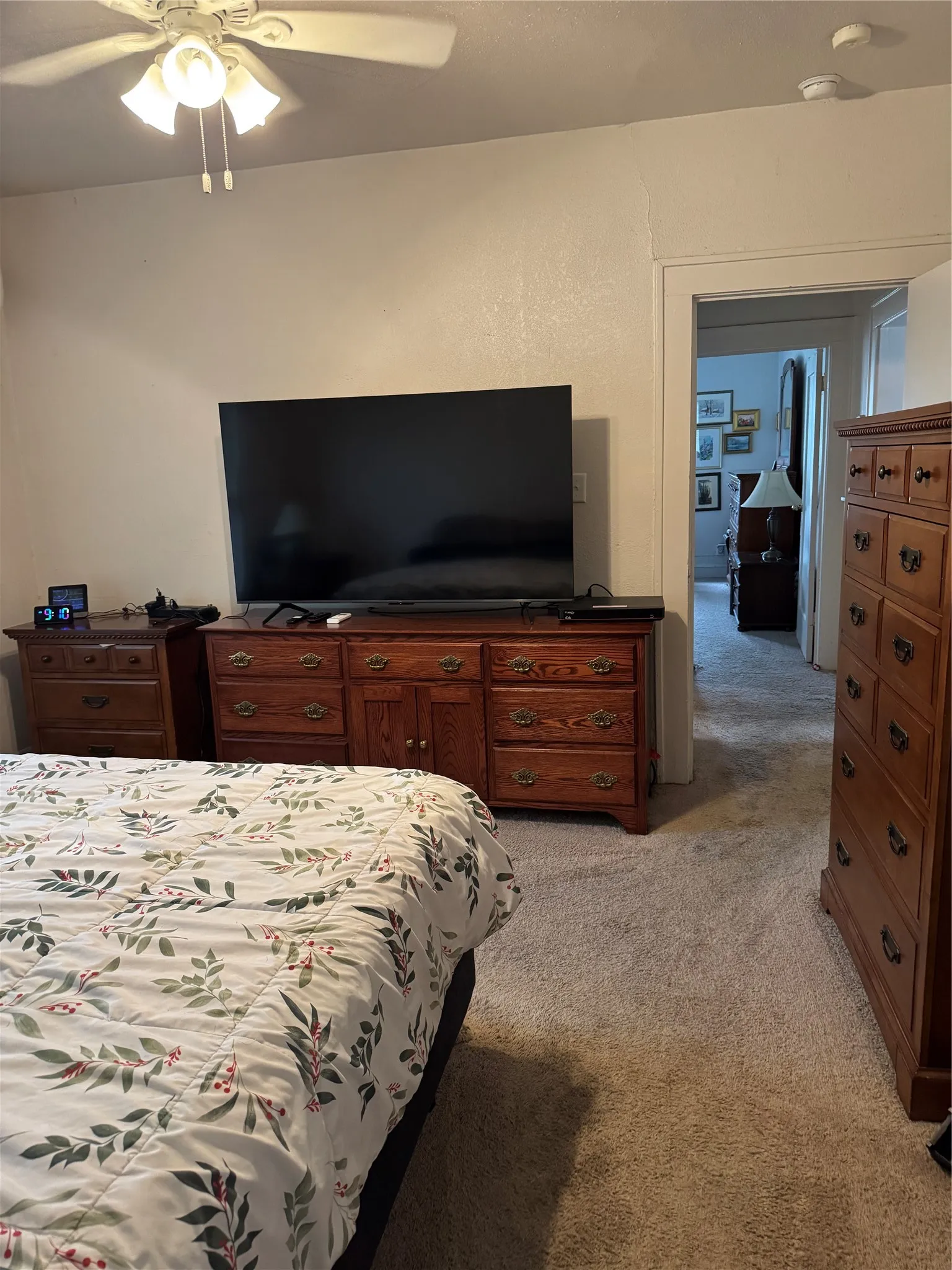Bedroom with light carpet and a ceiling fan