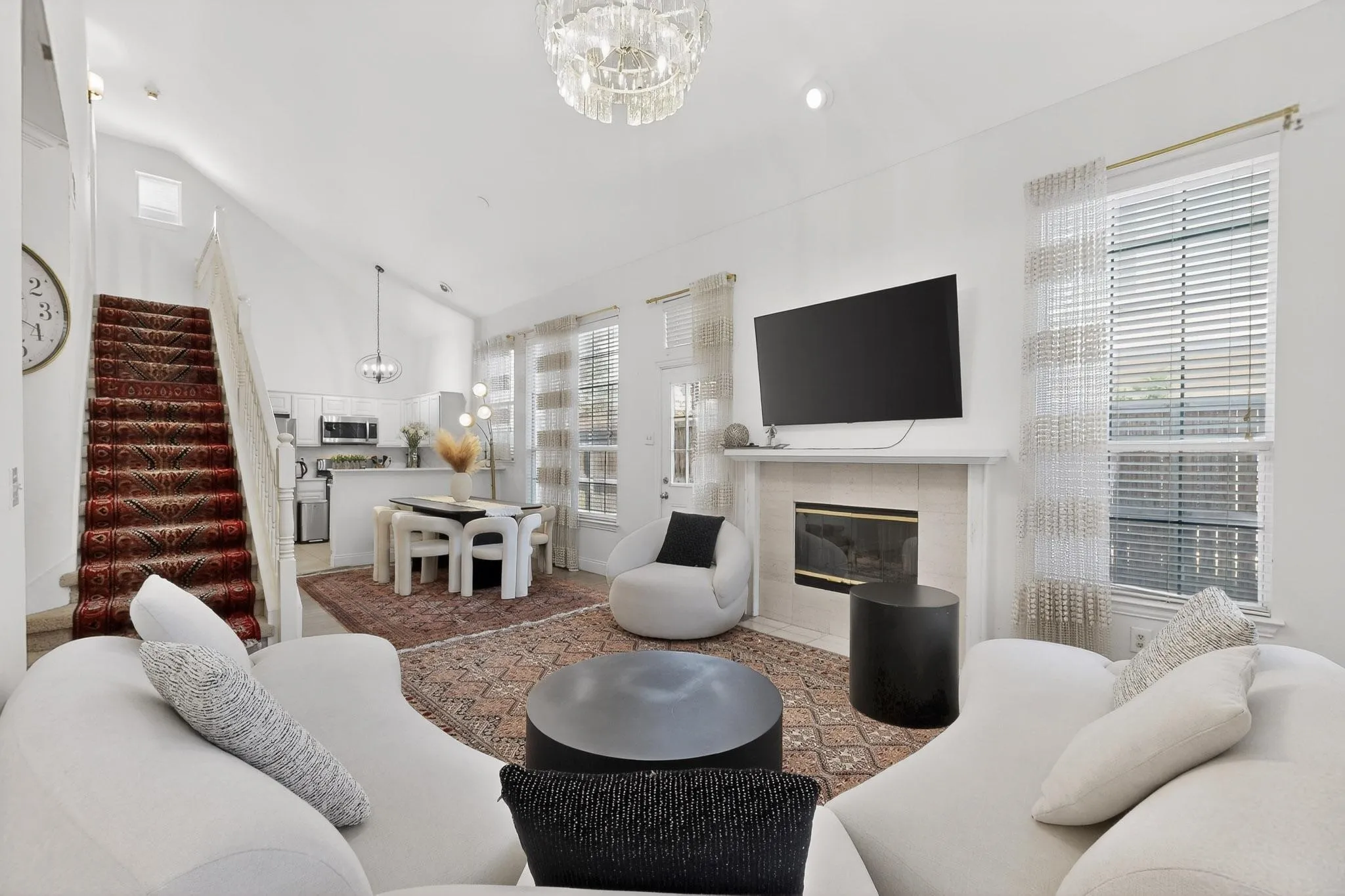 Living room featuring hanging lights, a fireplace, and lofted ceiling
