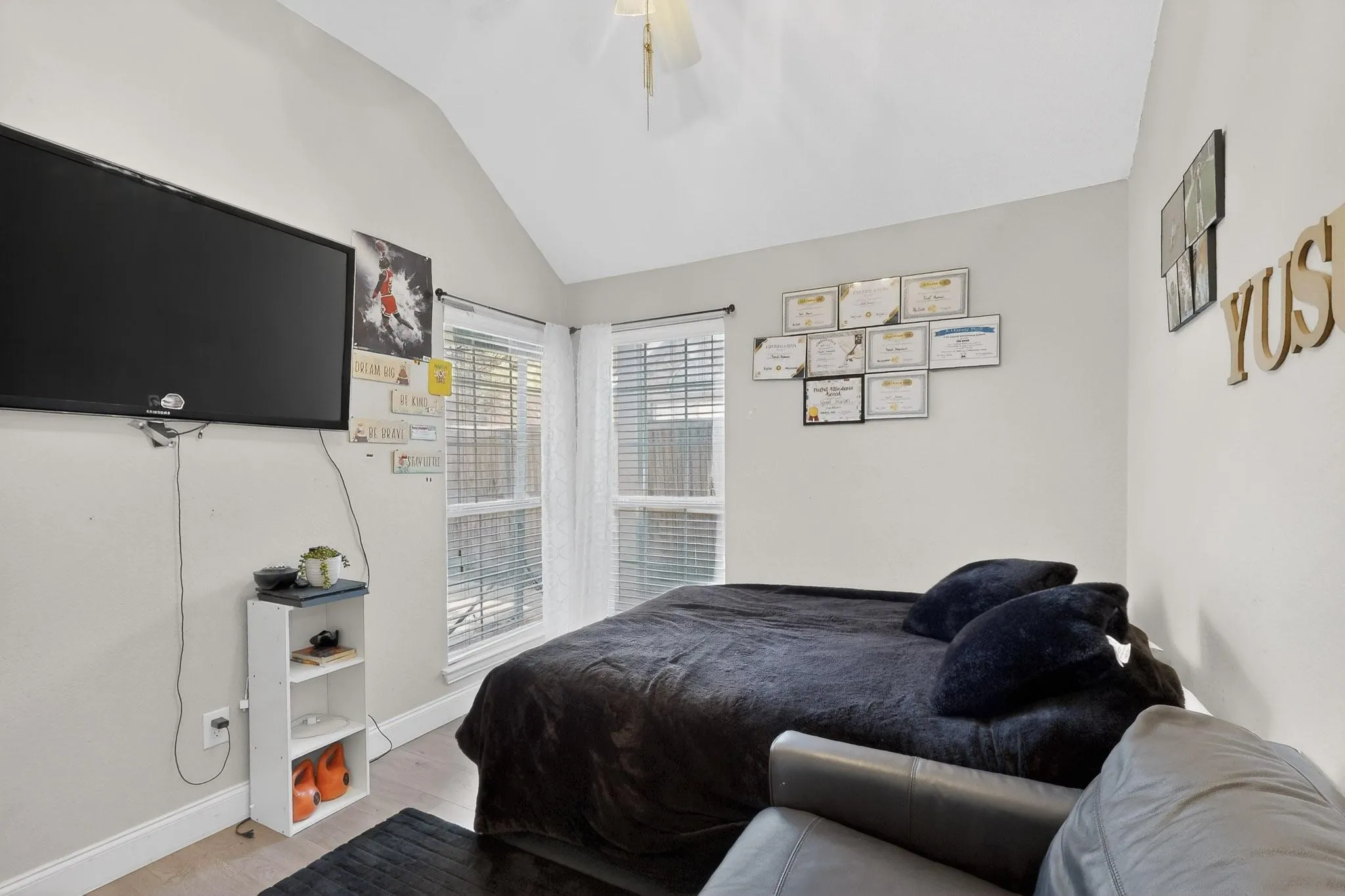 Bedroom with vaulted ceiling, light wood-style flooring, and a ceiling fan