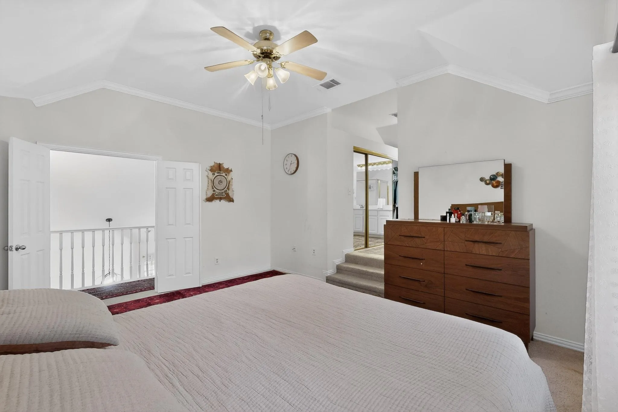 Carpeted bedroom featuring ornamental molding, lofted ceiling, a closet, and a ceiling fan