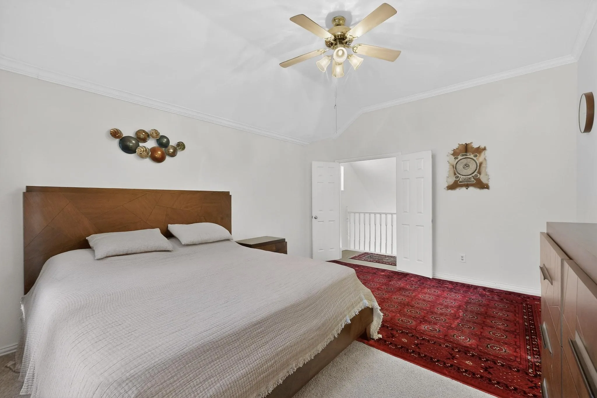 Bedroom with ornamental molding, ceiling fan, carpet, and lofted ceiling
