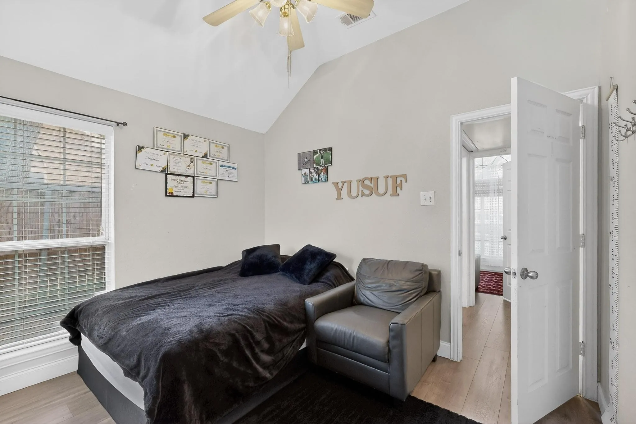 Bedroom with lofted ceiling, light wood-type flooring, and a ceiling fan