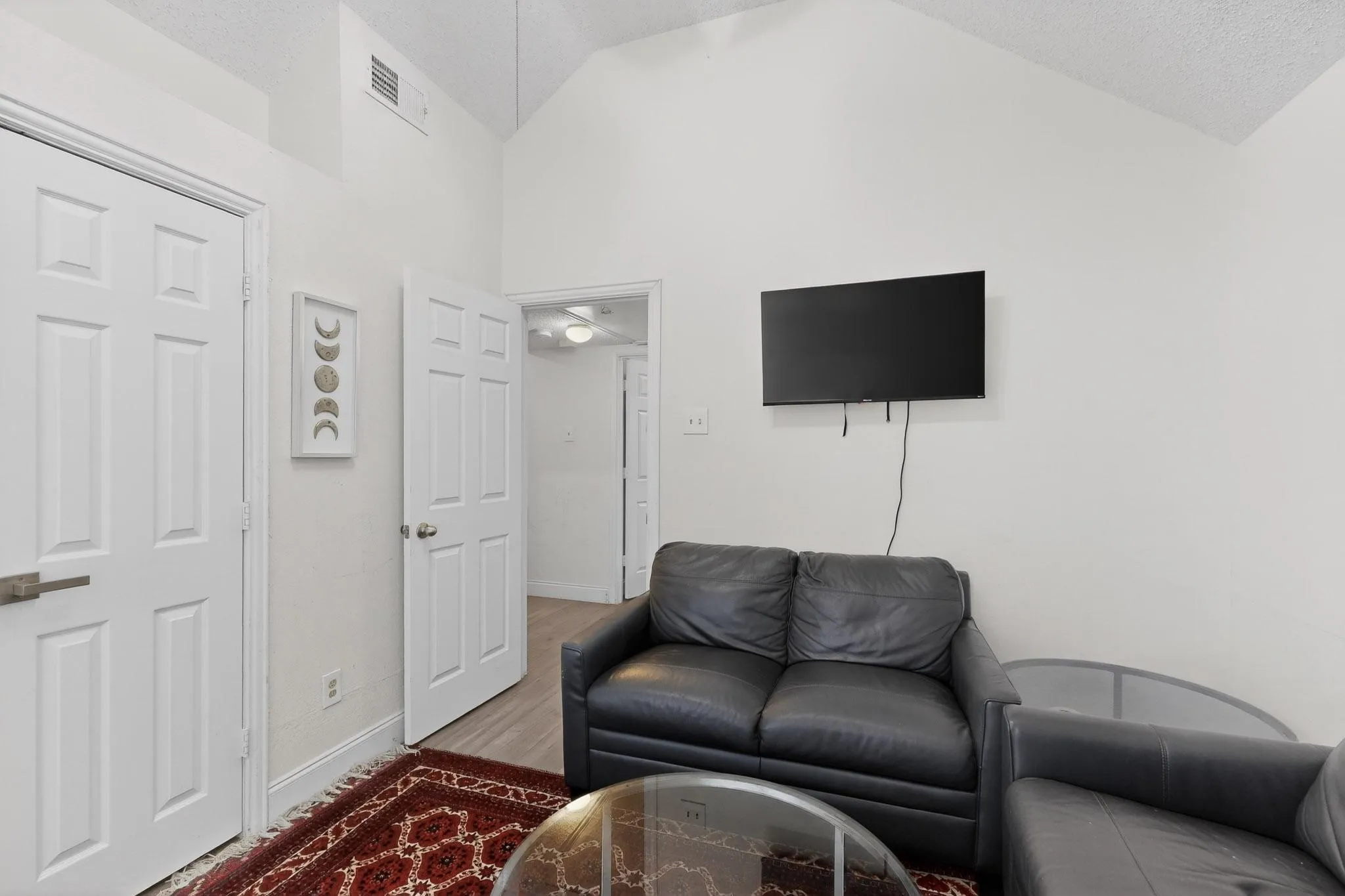 Living area with a high ceiling and light wood-style flooring