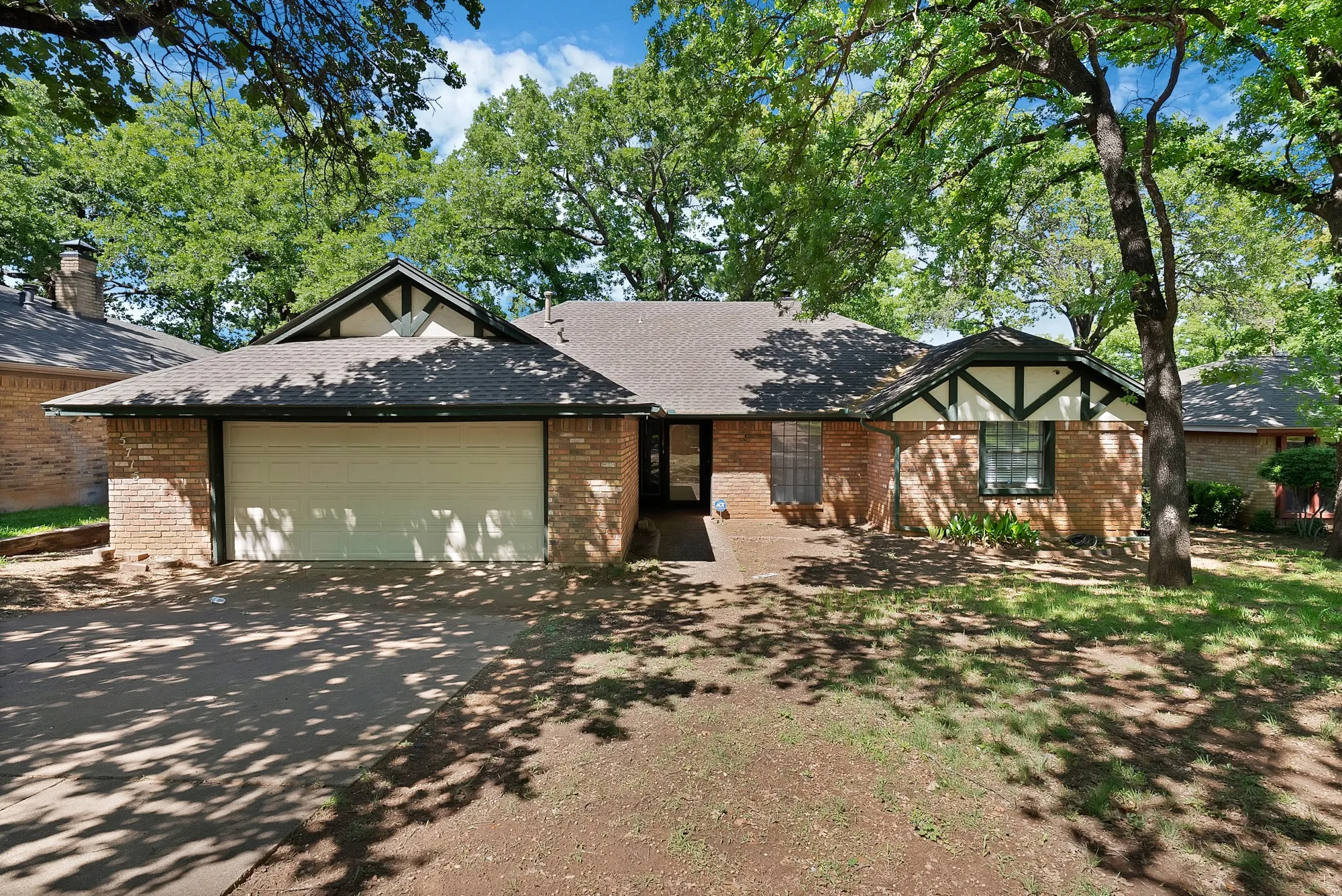 The property features a brick exterior with dark trim detailing and a light-colored garage door