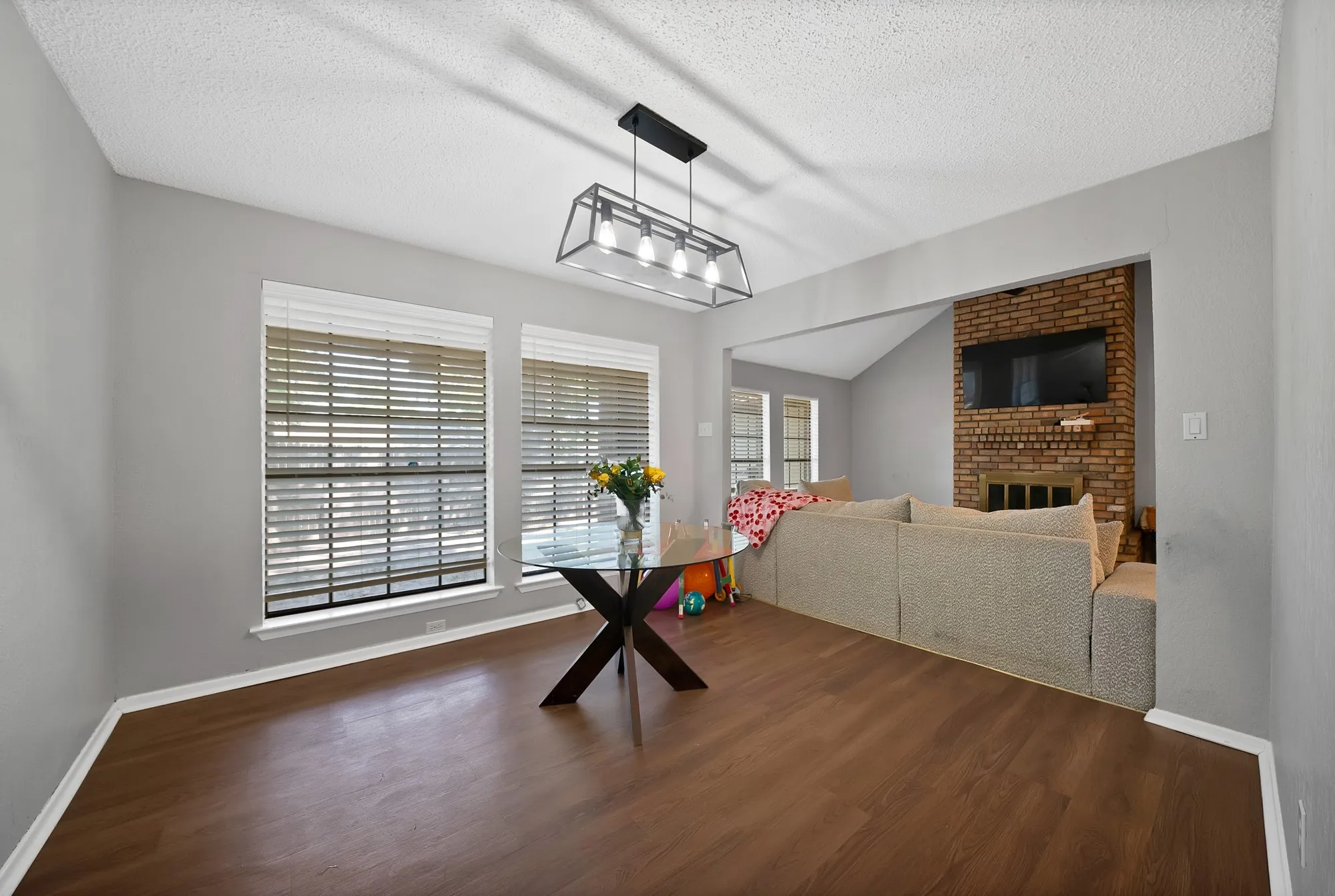 Dining room with a fireplace and dark wood-type flooring