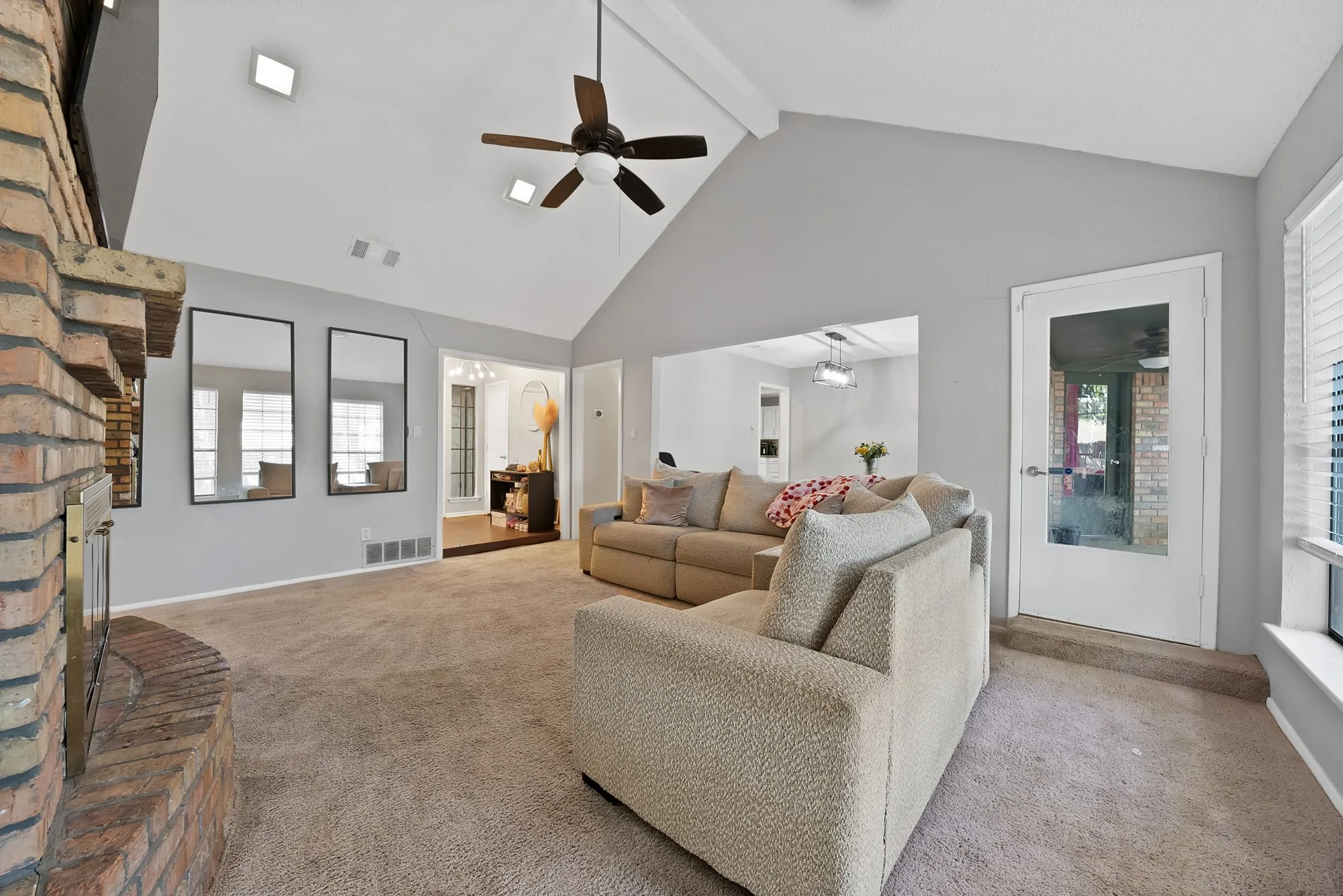 Living area featuring a fireplace, carpet floors, and a ceiling fan