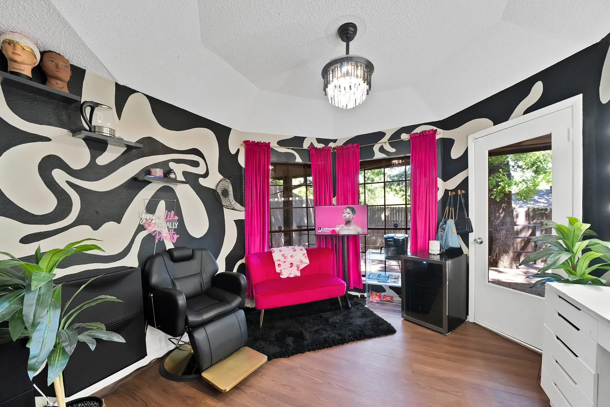 Living area with a textured ceiling, wood finished floors, and suspended lighting