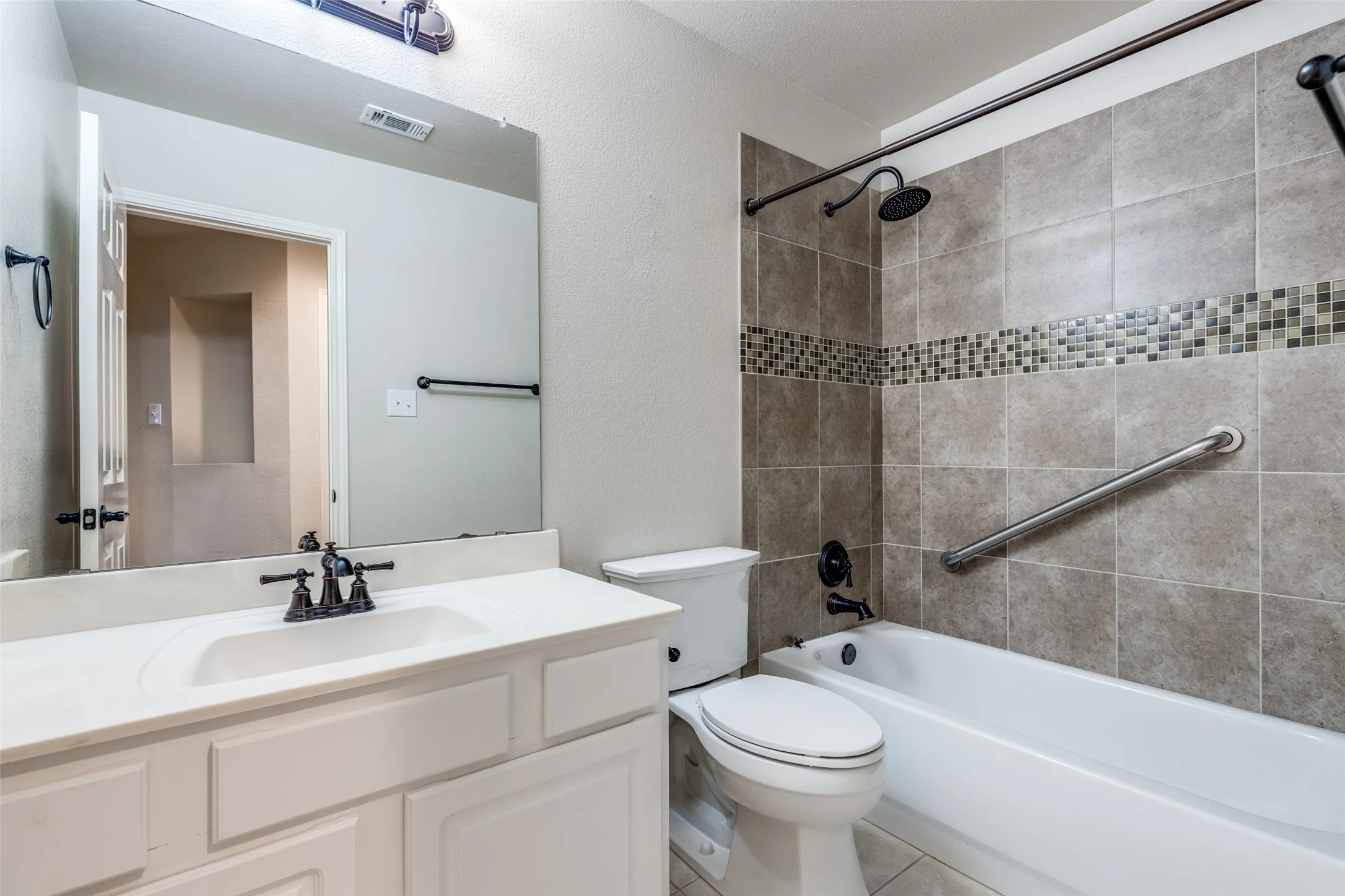 Guest bath contains updated fixtures and tiled shower enclosure.