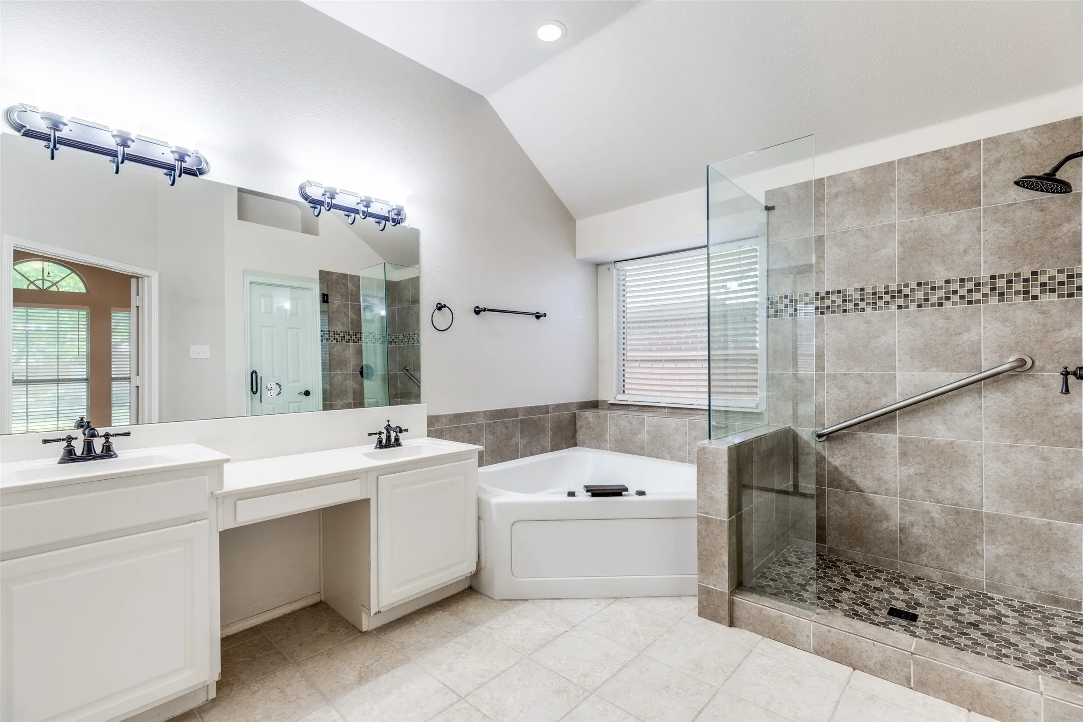 Luxury master bath has a separate garden tub and oversized tiled shower, plus dual sinks, a vanity, and a big walk-in closet.
