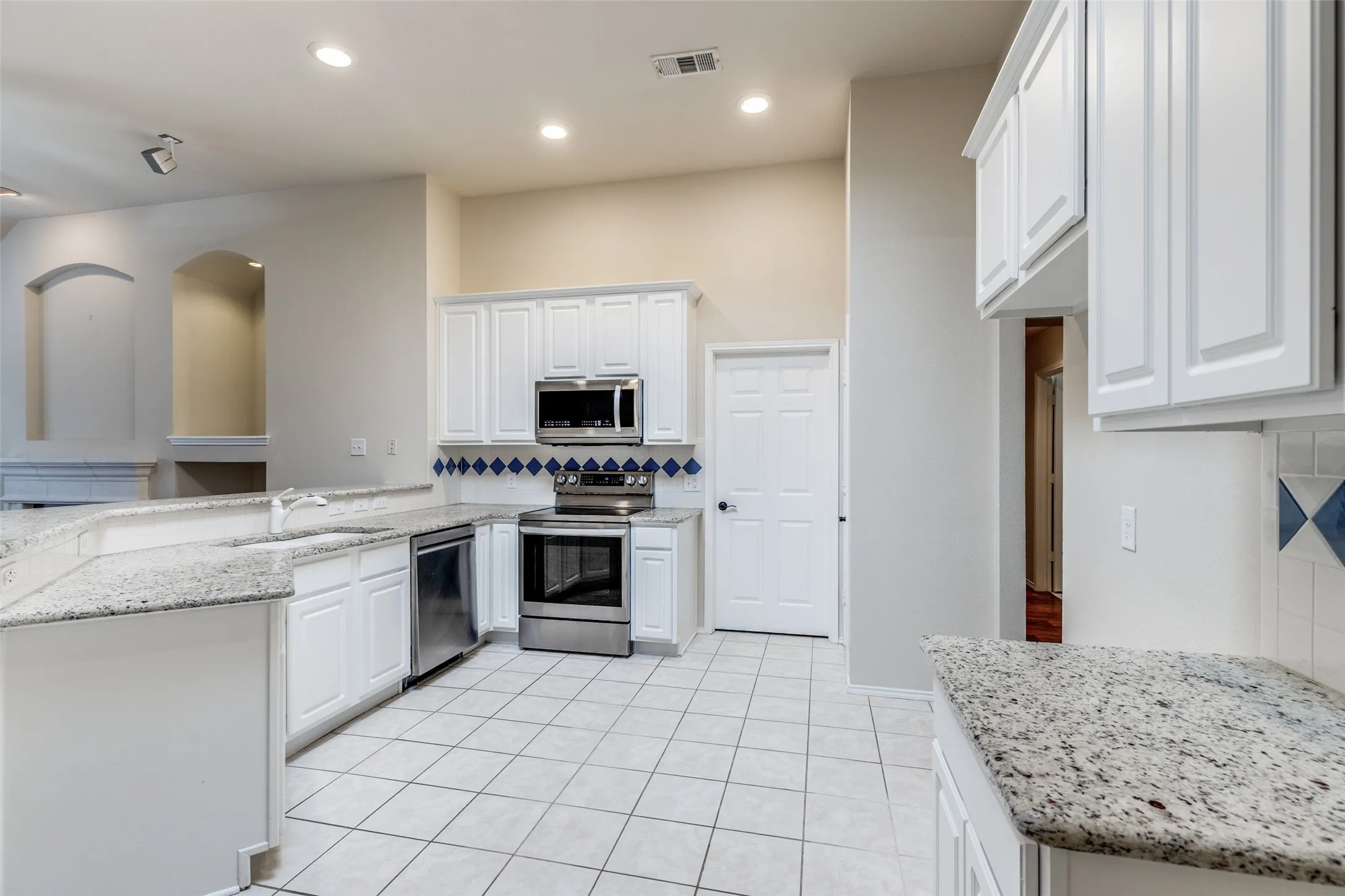 Granite countertops and stainless-steel appliances adorn the spacious kitchen.