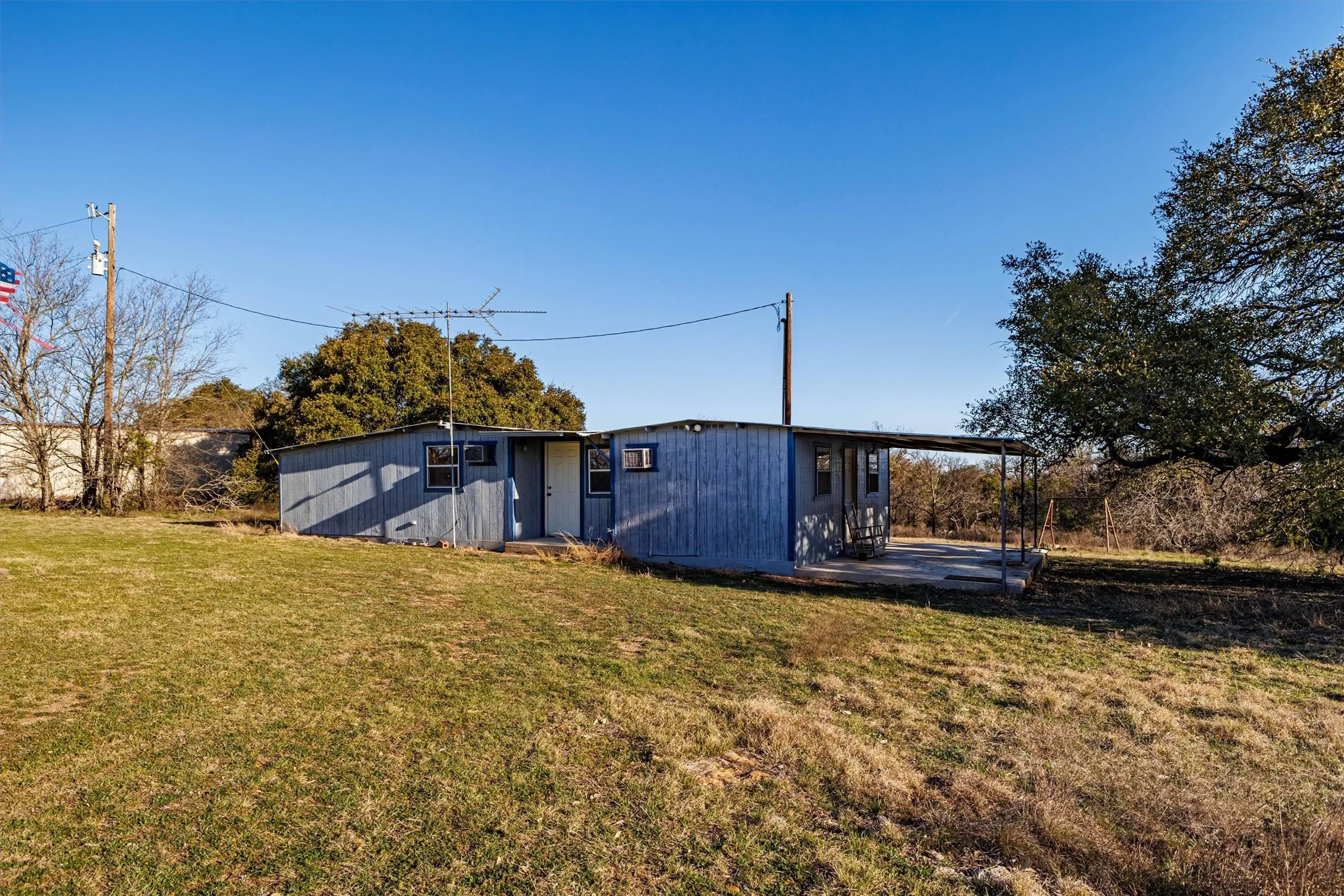 The property features a single-story structure with a covered porch and a surrounding grassy area