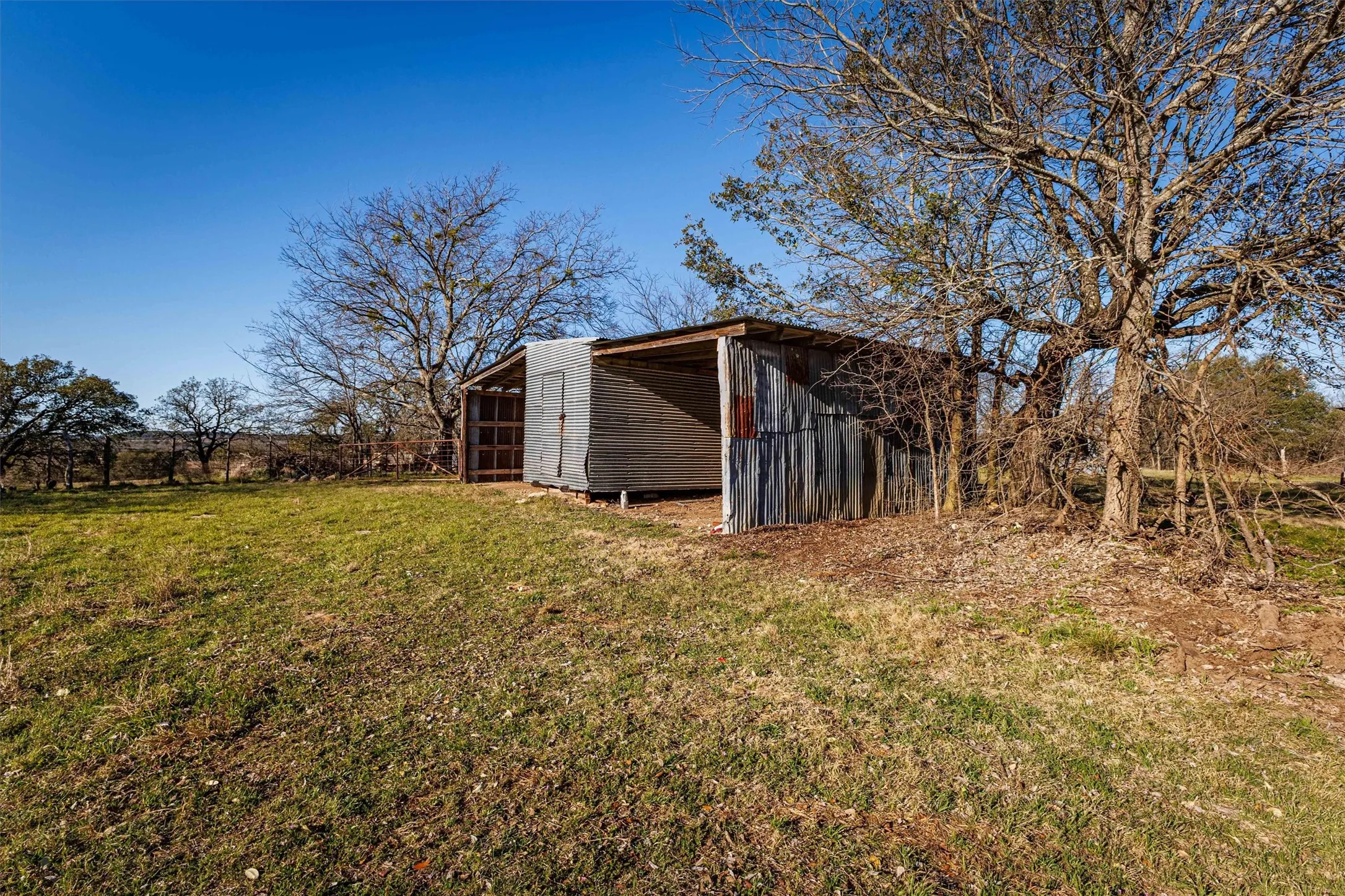 This property features a structure with corrugated metal siding and a large open area
