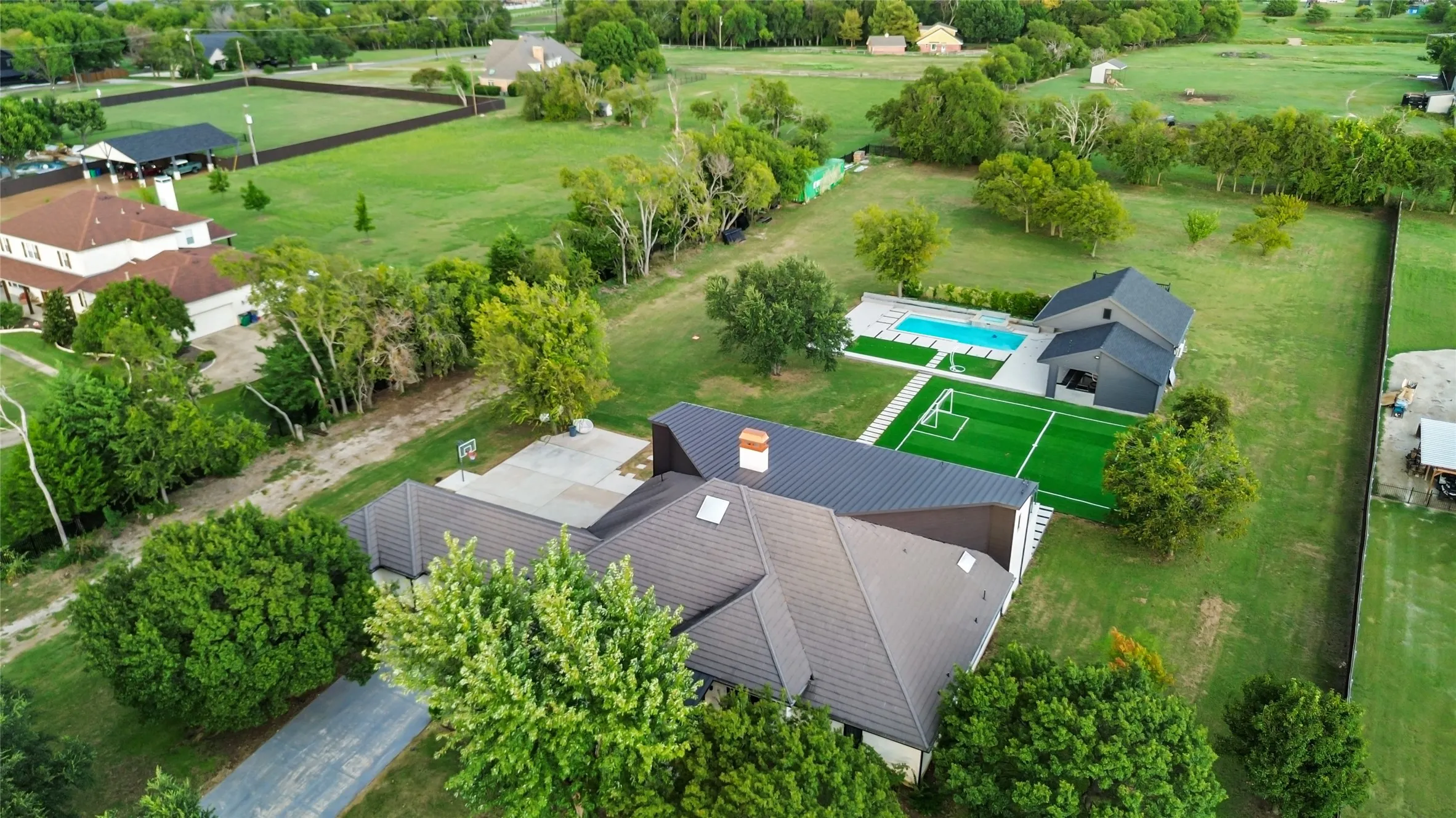 Bird's eye view of a pool and a tree filled landscape