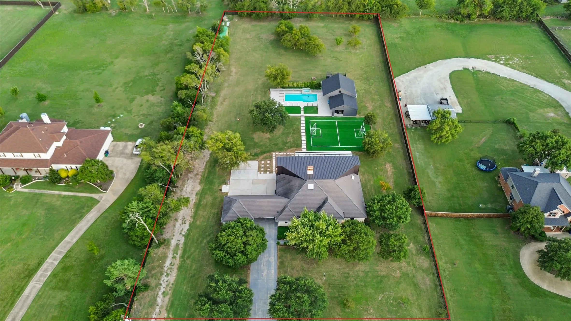 Aerial view of property and surrounding area featuring property boundaries highlighted and a pastoral area