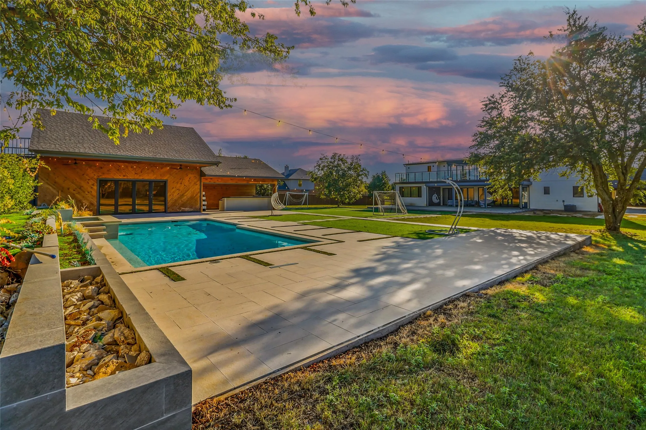 Outdoor pool featuring a lawn and a patio area