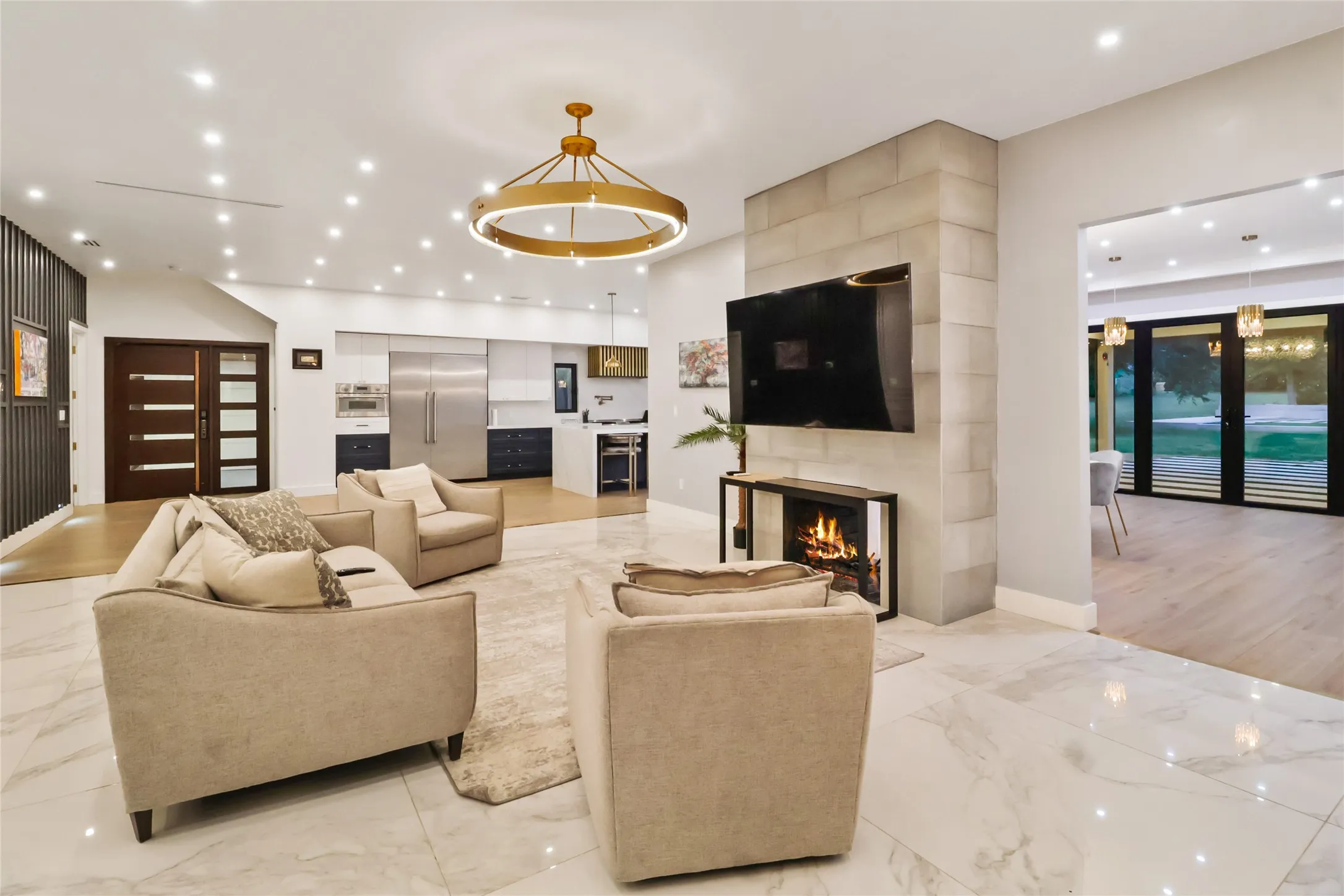 Living room with light marble finish floors, recessed lighting, and a large fireplace