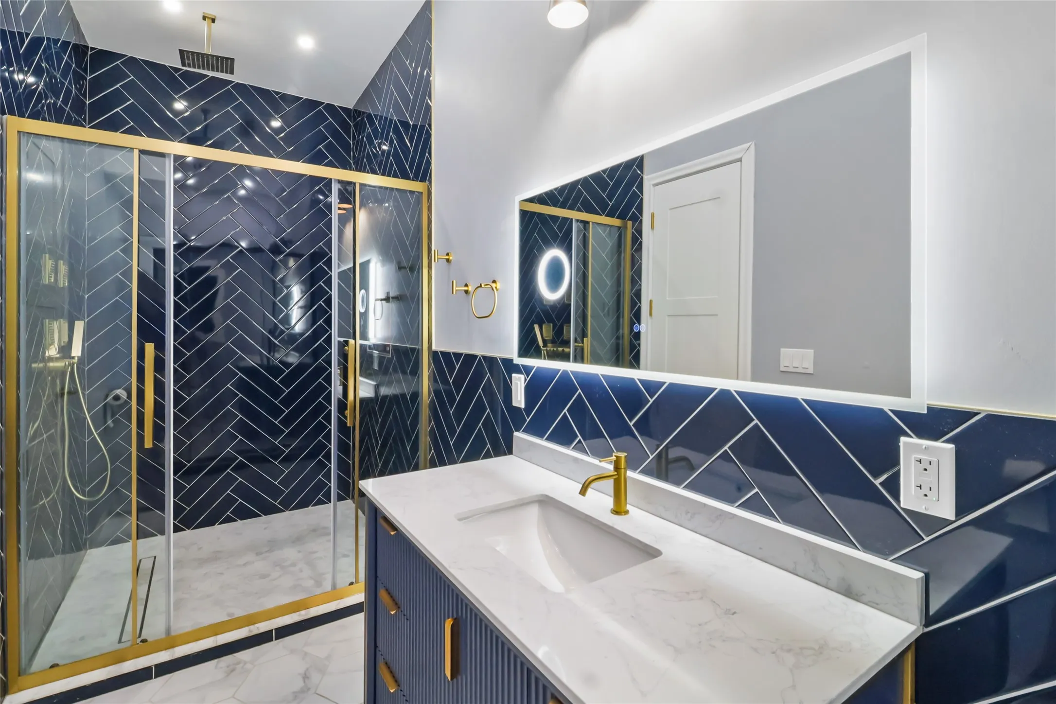 Full bath featuring tile walls, vanity, a shower stall, and light marble finish flooring