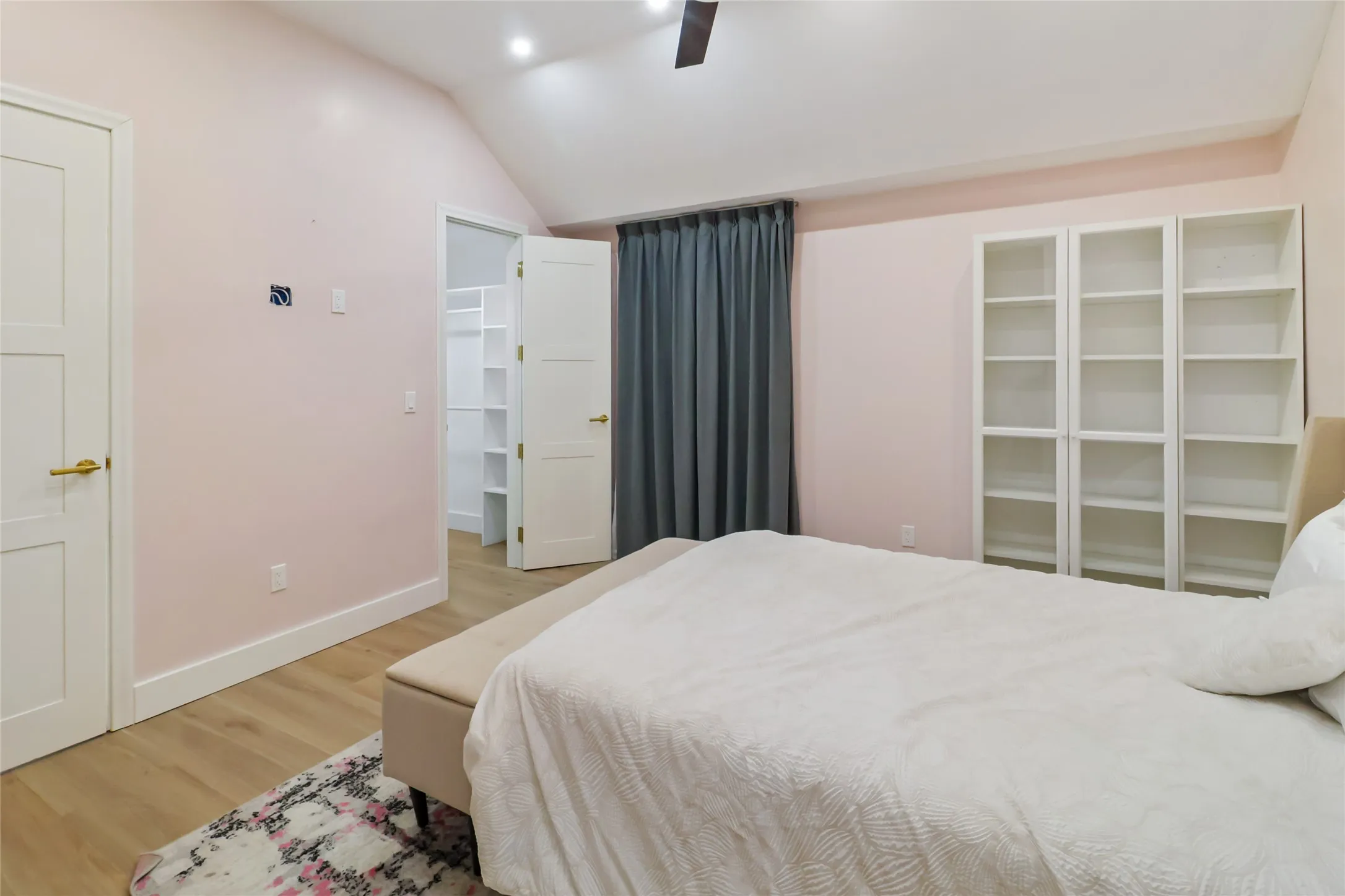 Bedroom with light wood-style floors, vaulted ceiling, a walk in closet, ceiling fan, and recessed lighting