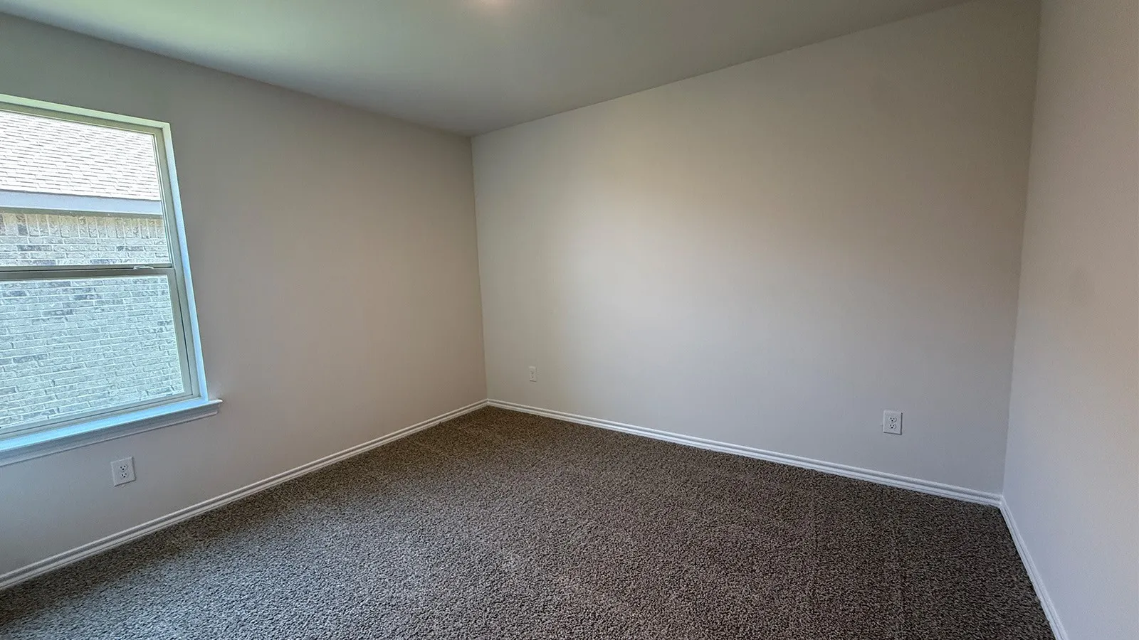 Carpeted room featuring a single window and neutral wall tones