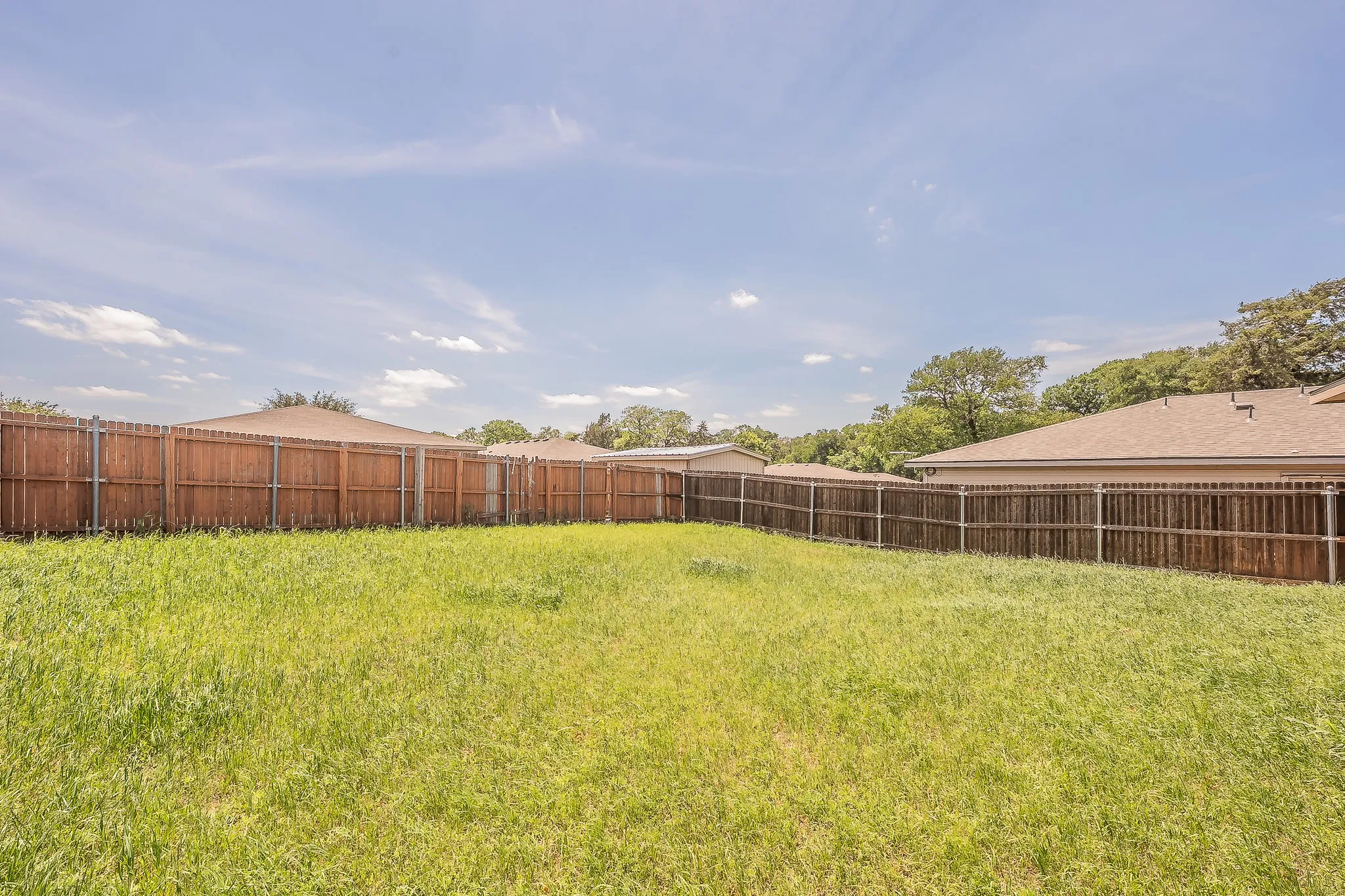 Expansive backyard featuring a natural grass lawn