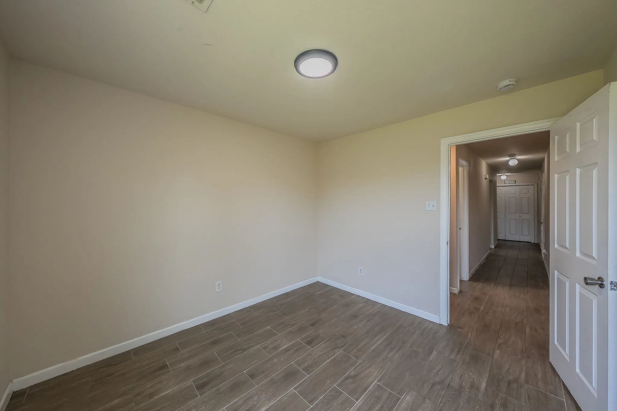 Room featuring neutral wall tones and wood-finish tile flooring