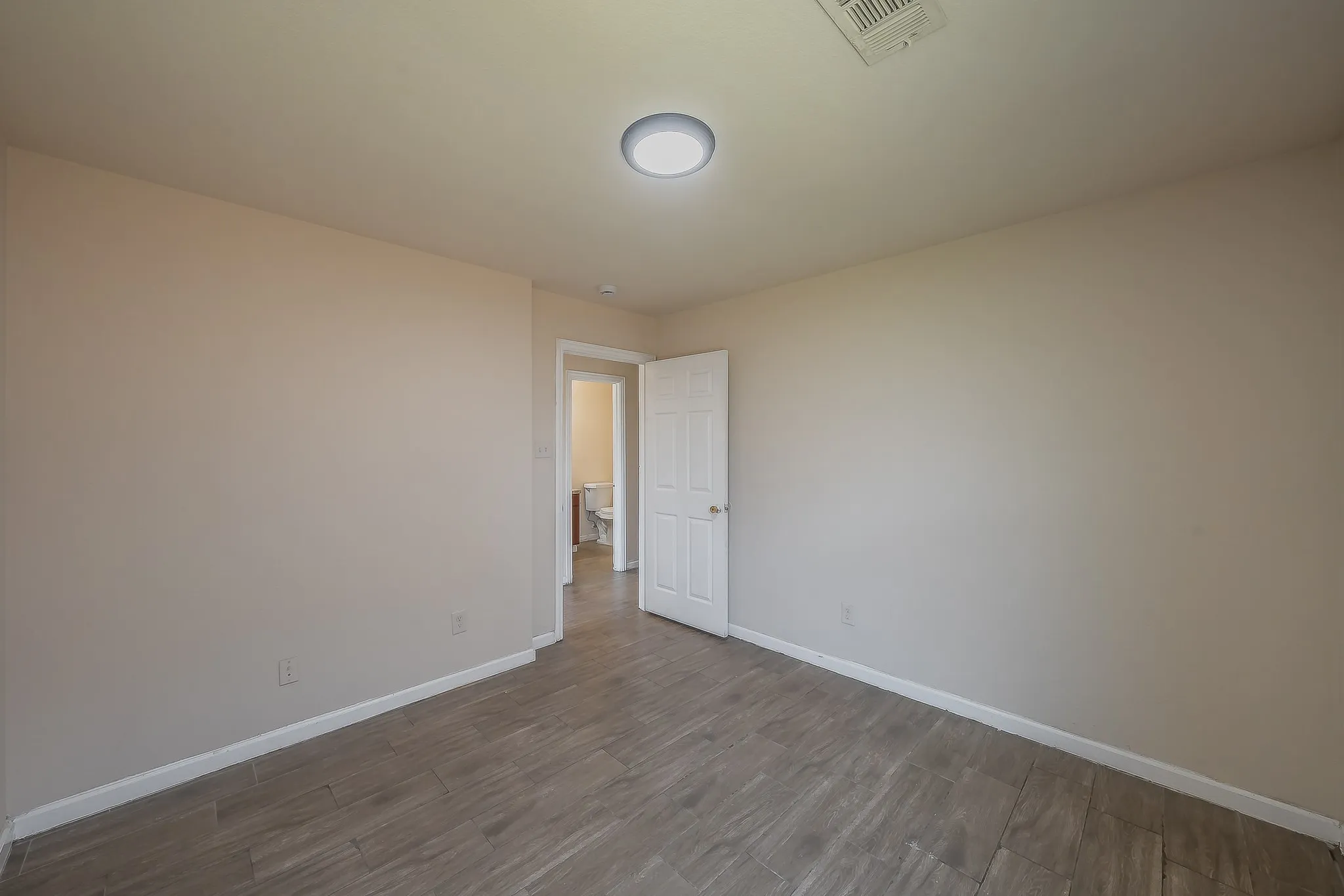 Neutral wall tones and wood-finish tile flooring