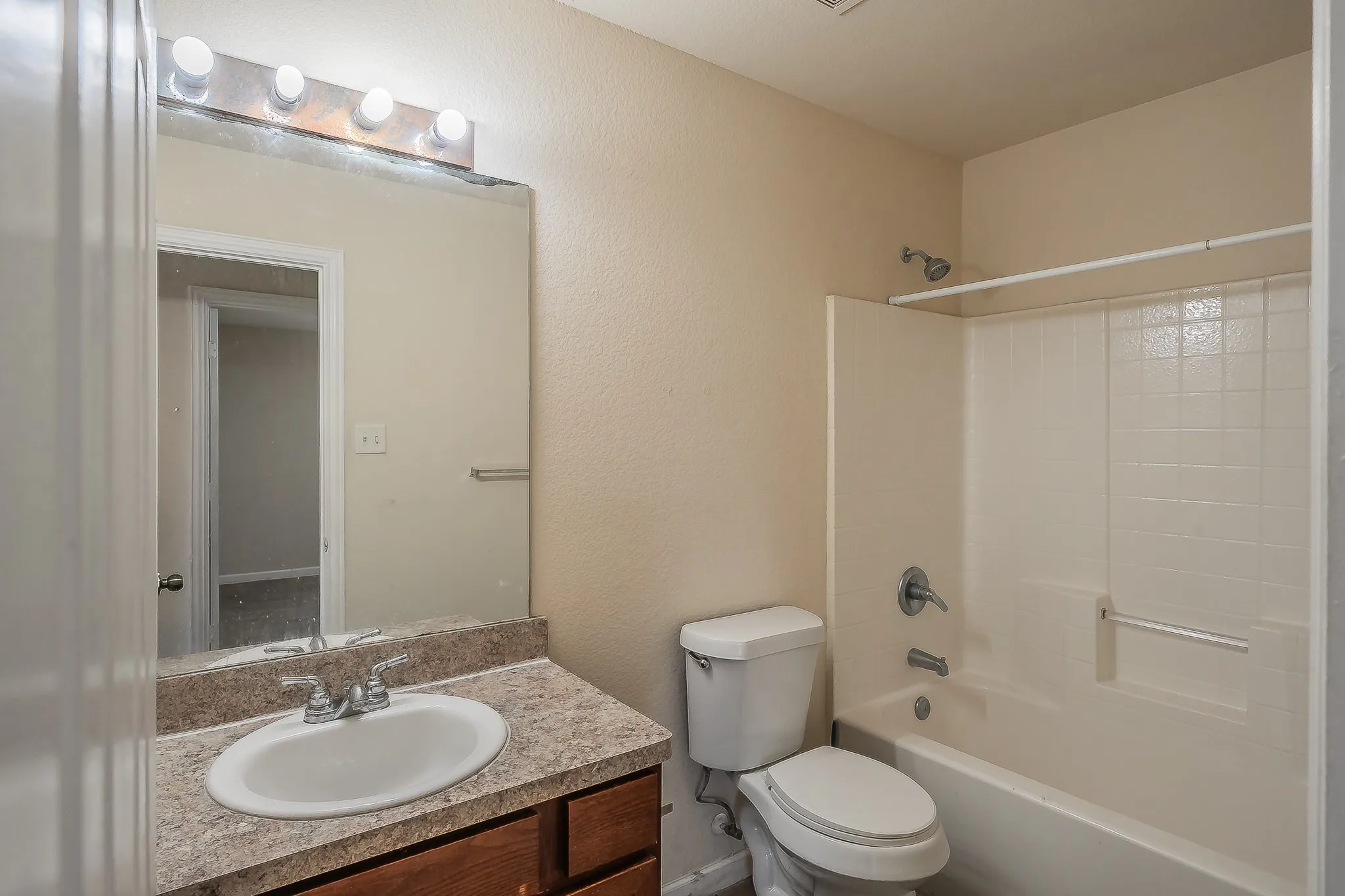 Bathroom vanity with a top-mounted sink, chrome faucet, and integrated overhead lighting