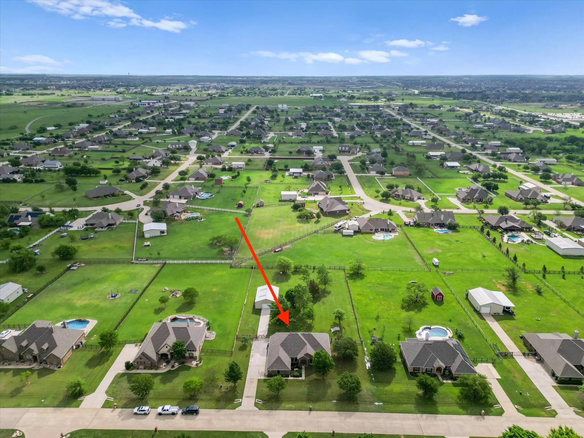 Aerial view showcasing the property situated within a neighborhood featuring extensive green spaces and other homes