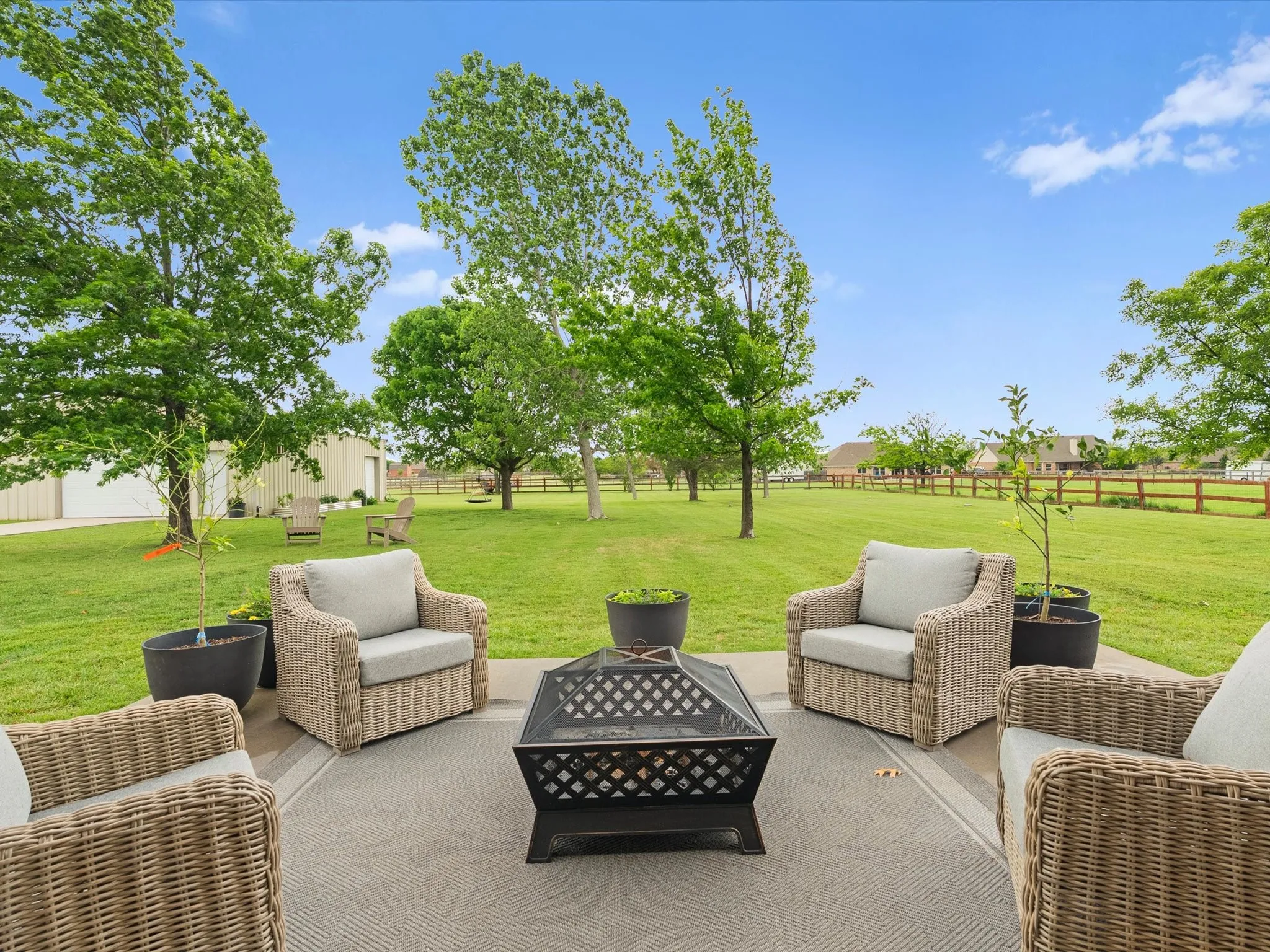 This property features an expansive green lawn with mature trees and a fenced boundary