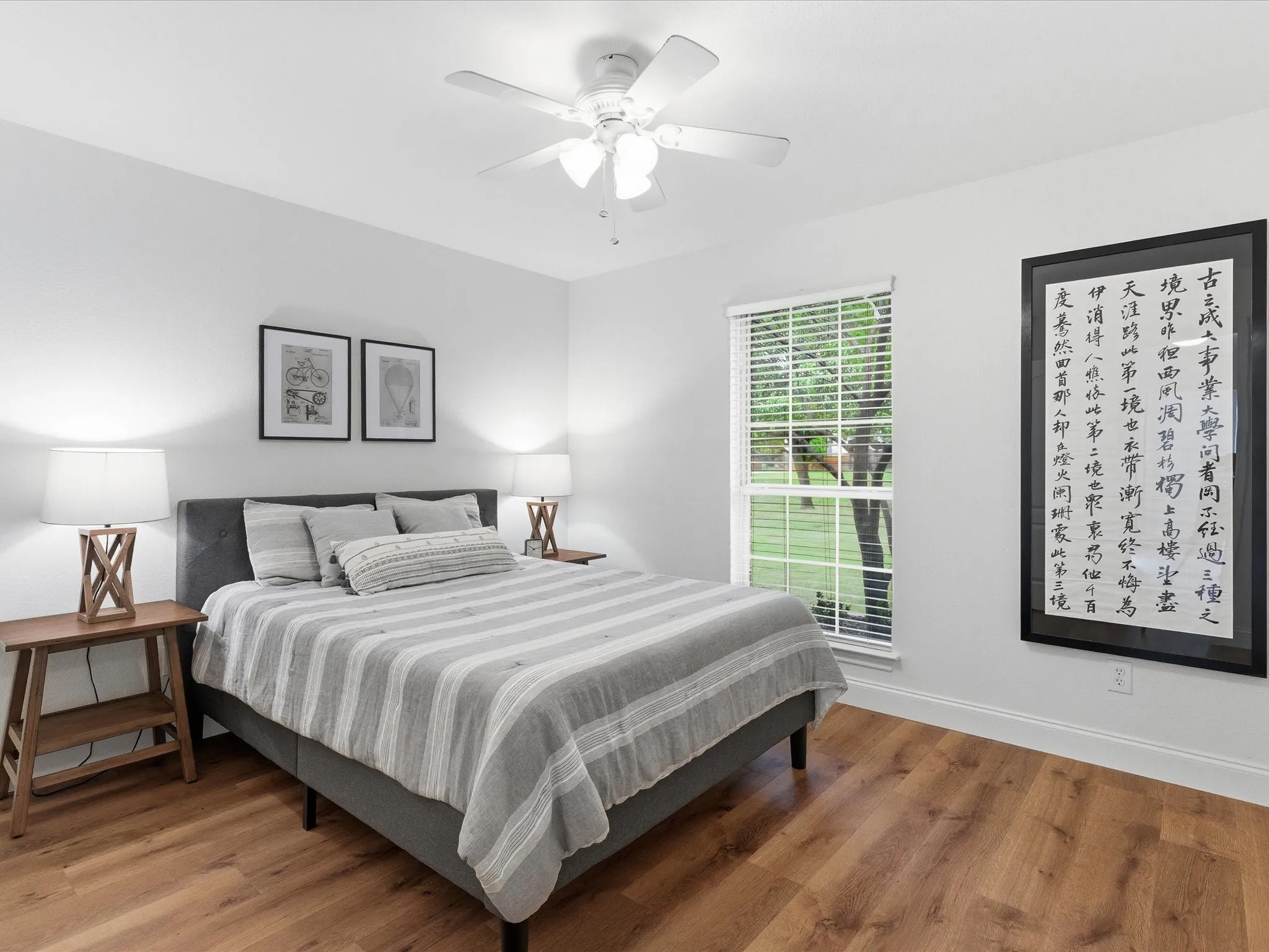 Bedroom featuring wood-style flooring, a ceiling fan, and a window with blinds providing natural light