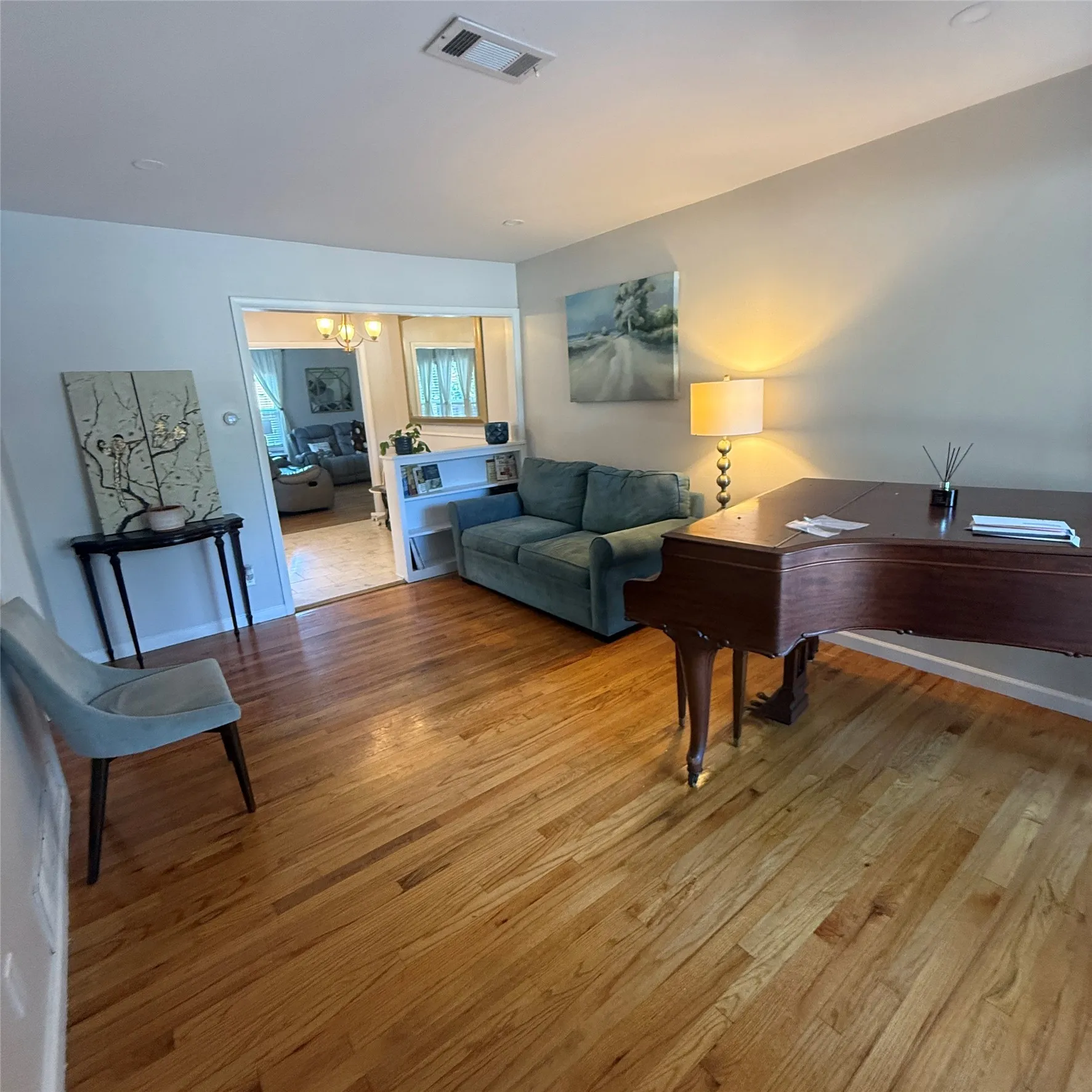 The interior features hardwood flooring throughout, a neutral wall color, and recessed lighting