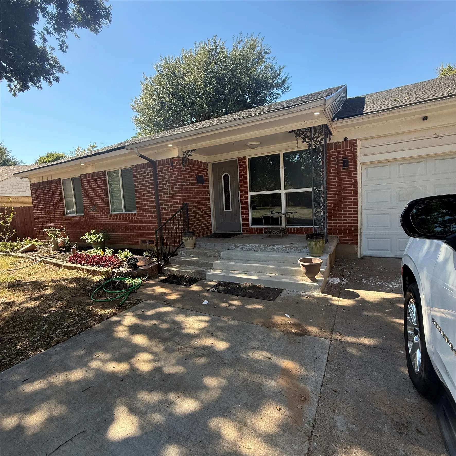 The property features a brick exterior, an attached garage, and a concrete driveway