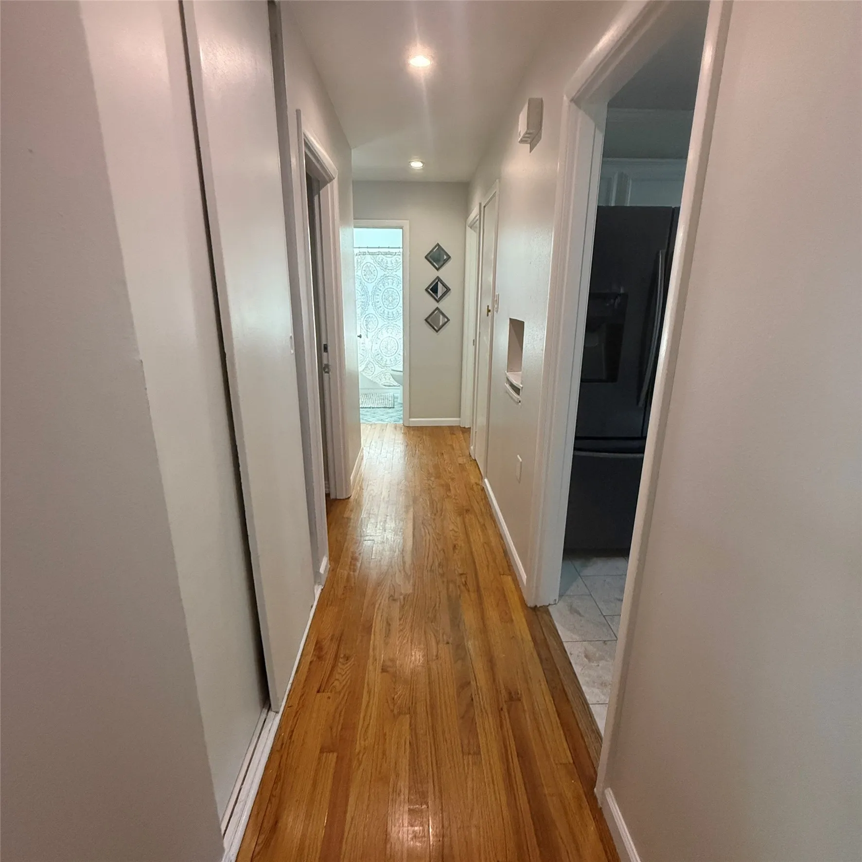 Hallway featuring polished hardwood flooring and recessed lighting