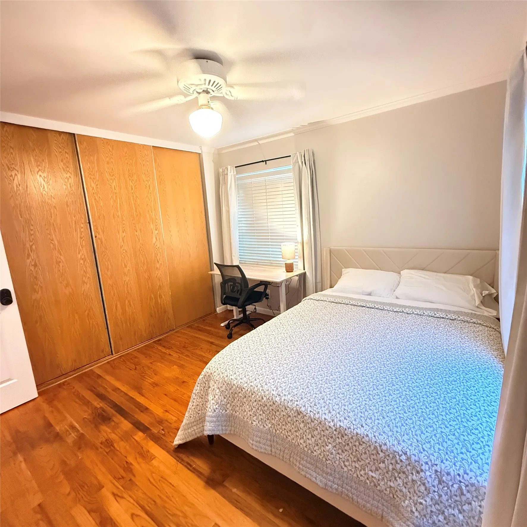 This room features hardwood floors and a ceiling fan