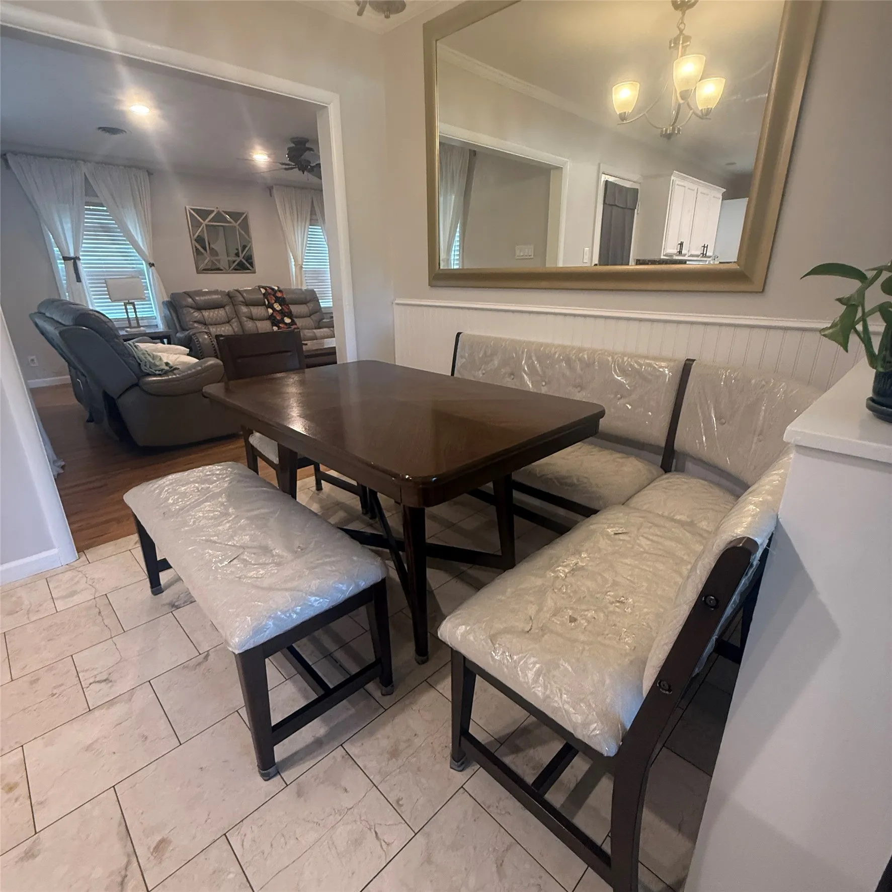 The property features a dining area with tiled flooring and a dark wood dining table, complemented by a built-in bench seating arrangement