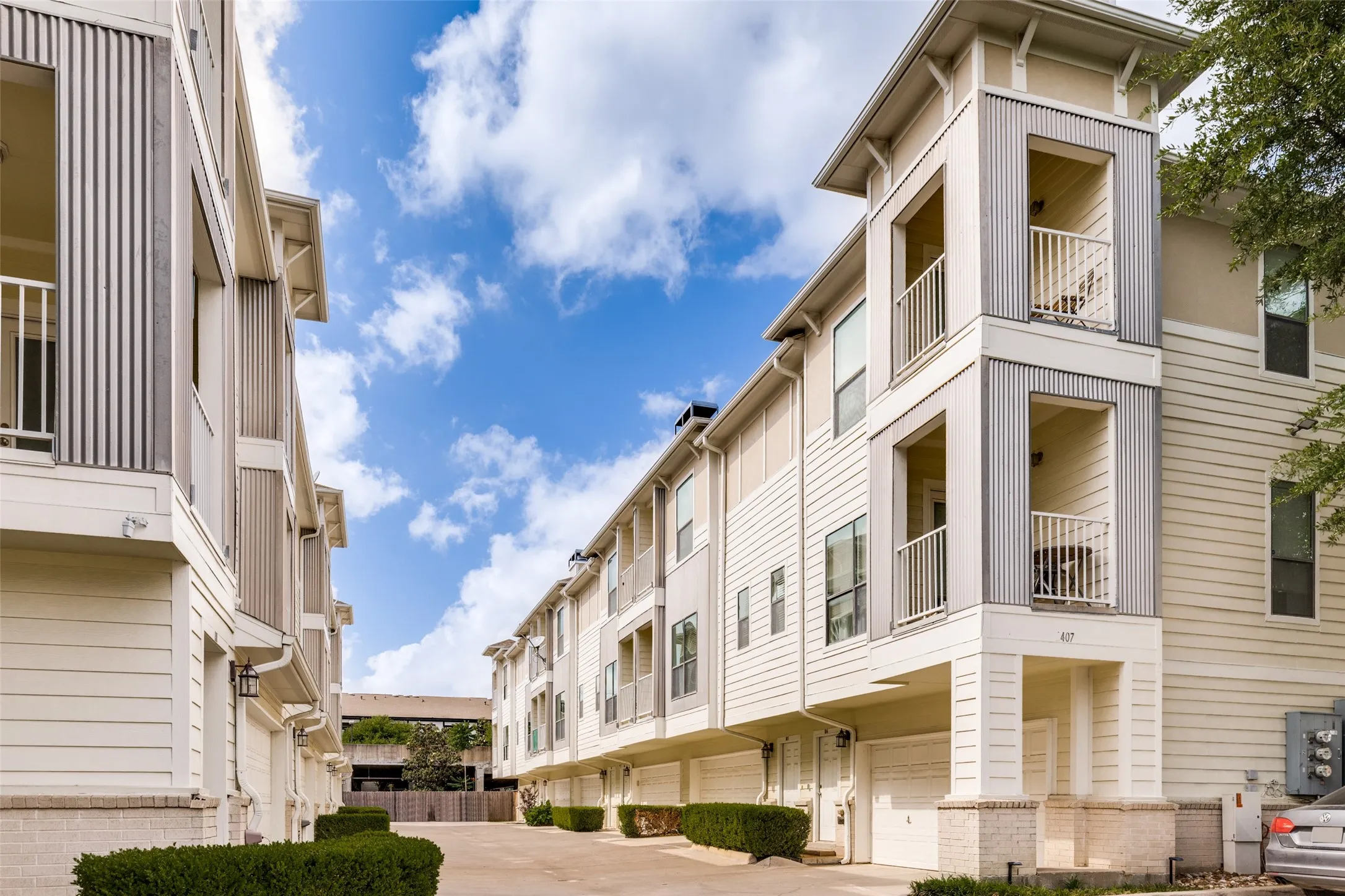 The property features a modern exterior with horizontal siding and corrugated metal accents, along with private balconies