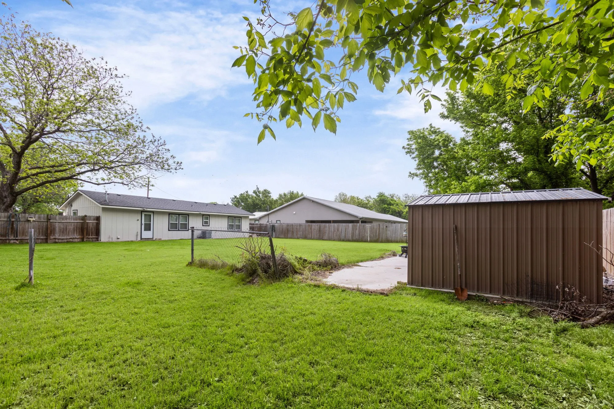 Fenced backyard with a storage shed